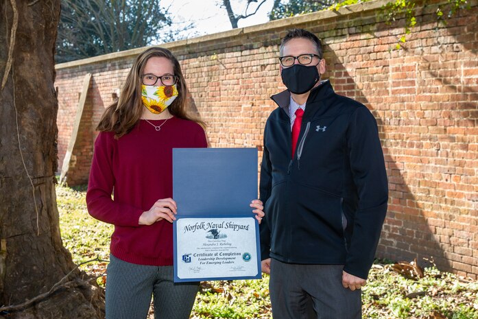 Norfolk Naval Shipyard’s Emerging Leaders Program Manager Dave Randall awards Emergency Management Specialist (Code 1130) Alyx Riebeling with a certificate upon completing the Leadership Development for Emerging Leaders computer-based training program.