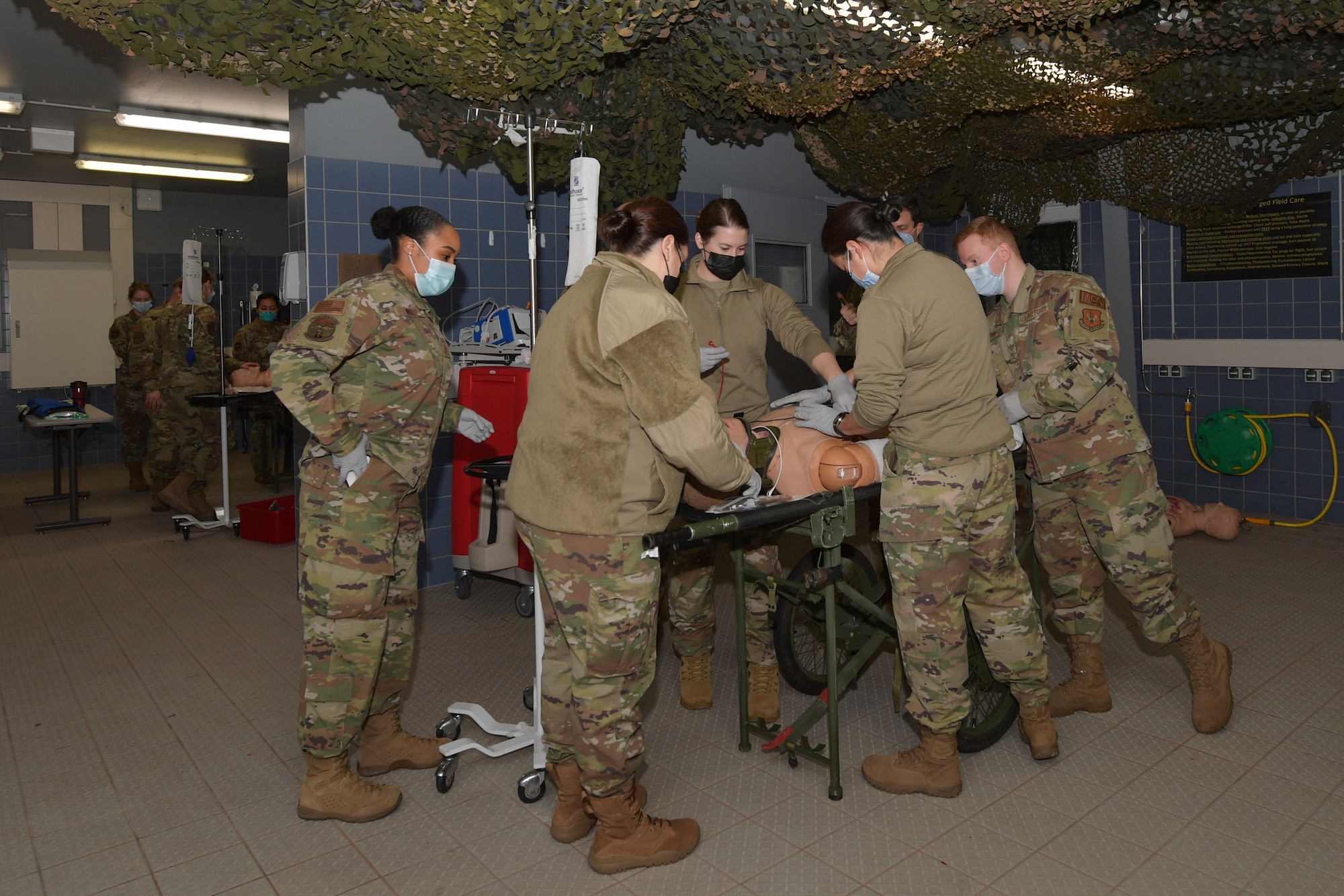 Airmen standing around a simulated medical patient mannequin.