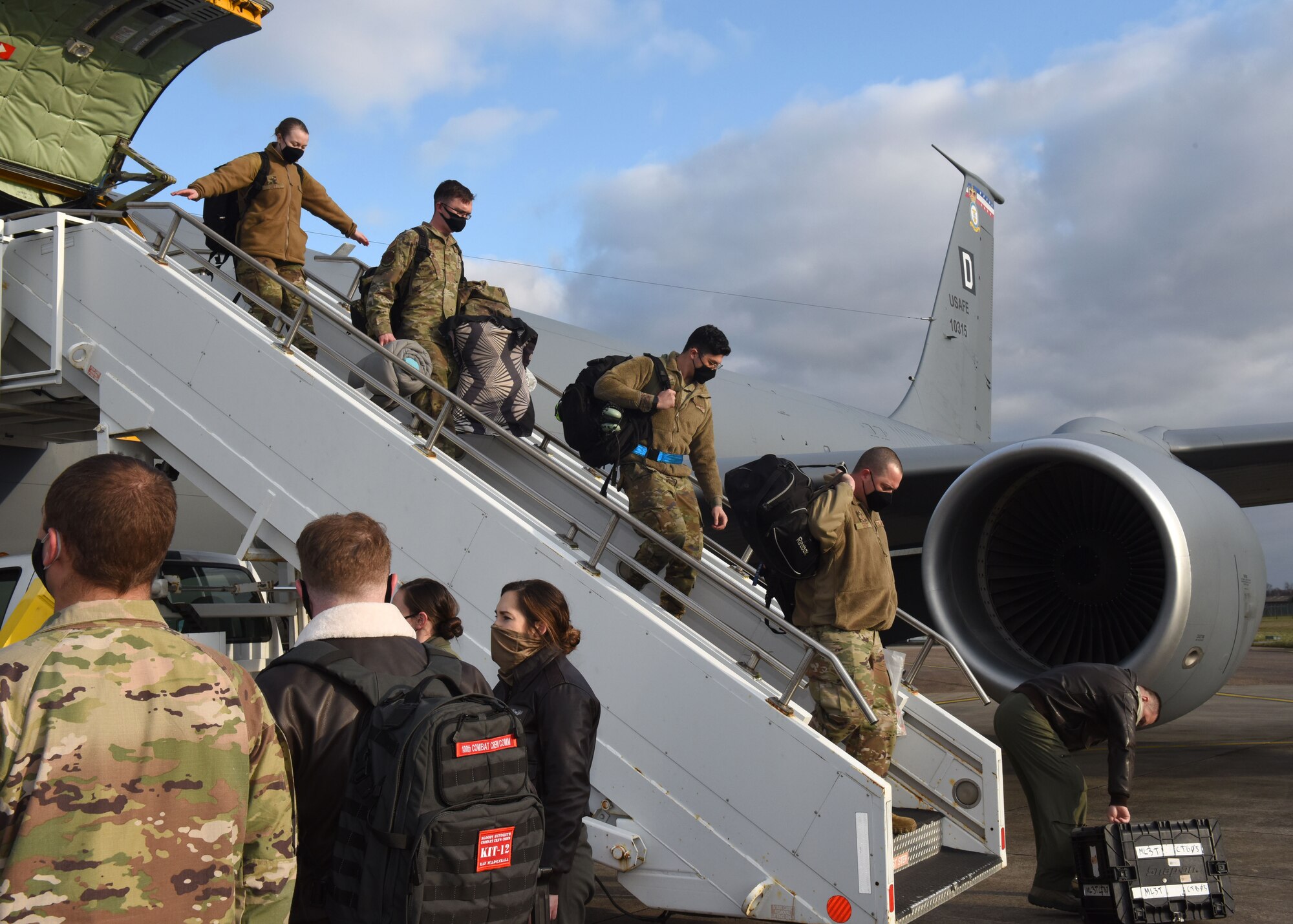 Airmen from the 100th Operations Group and 100th Maintenance Group exit a KC-135 Stratotanker aircraft after returning home from a deployment Feb. 1, 2021, at Royal Air Force Mildenhall, England. Airmen from the Bloody Hundredth provided vital support for the movement of Department of Defense assets including the relocation of U.S. forces in Somalia. During the deployment, 100th Air Refueling Wing aircraft and Airmen offloaded 2.29 million pounds of fuel to 228 receivers and conducted more than 47 missions for a total of 258.8 hours. (U.S. Air Force photo by Karen Abeyasekere)