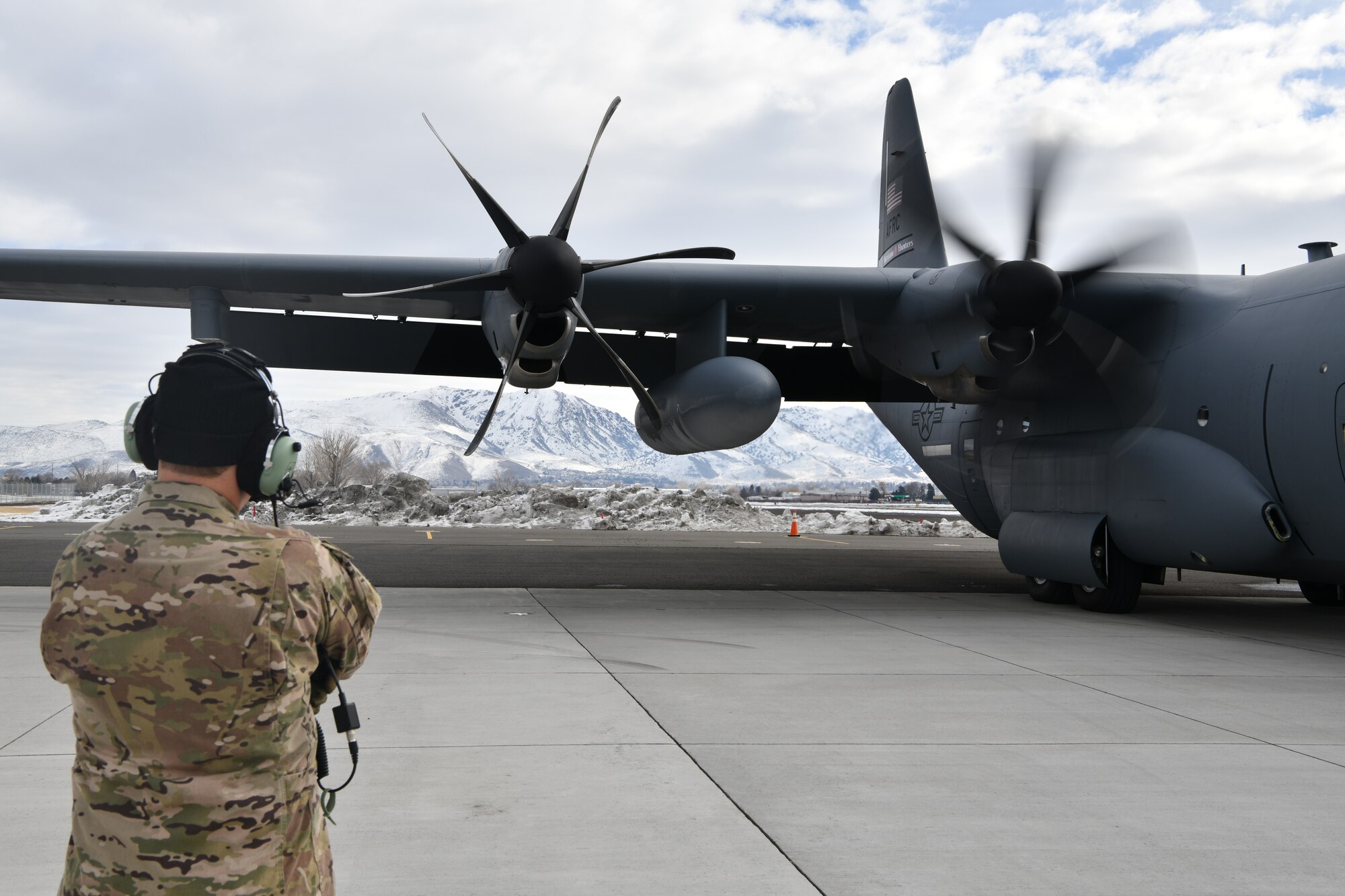Master Sgt. Chris Becvar, loadmaster for the 53rd Weather Reconnaissance Squadron at Keesler Air Force Base, Miss., looks on as the propellers begin to turn on a WC-130J "Hurricane Hunter" at Reno-Tahoe International Airport, Nev., Jan. 31, 2021. As a loadmaster Becvar is responsible for a multitude of tasks including monitoring the aircraft's operability in flight as well as dropping dropsondes from a specialized pallet to collect weather data. (U.S. Air Force photo by Staff Sgt. Kristen Pittman)