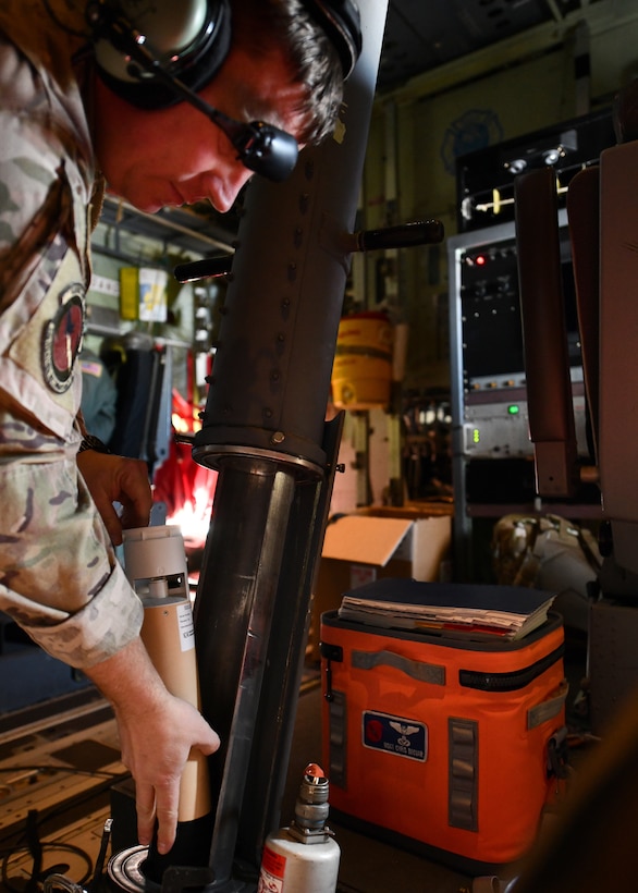 Master Sgt. Chris Becvar, Loadmaster for the 53rd Weather Reconnaissance Squadron at Keesler Air Force Base, Miss., loads a dropsonde into a chute during an atmospheric river reconnaissance flight out of Reno-Tahoe International Airport, Nev., Jan. 31, 2021. Upon it's release, the dropsonde measures atmospheric data such as barometric pressure, temperature, and humidity and transmits the data back to the WC-130J where it is assimilated into forecasts. (U.S. Air Force photo by Staff Sgt. Kristen Pittman)
