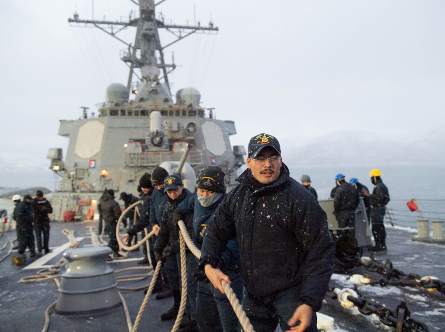 Sailors assigned to the Arleigh Burke-class guided-missile destroyer USS Ross (DDG 71) heave in storm lines in preparation to get underway