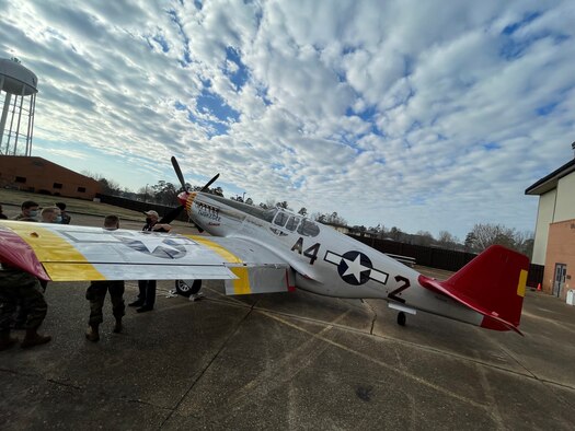 Air Force members talk amongst one another while a P-51C Mustang sits on the Columbus Air Force Base, Miss. flightline, during a static display on Feb. 10, 2020. The Commemorative Air Force Red Tail Squadron’s P-51C, named “Tuskegee Airmen”, is an authentic and fully restored operational fighter from the World War II era. (U.S Air Force photo by Tech Sgt. Javier Cruz)
