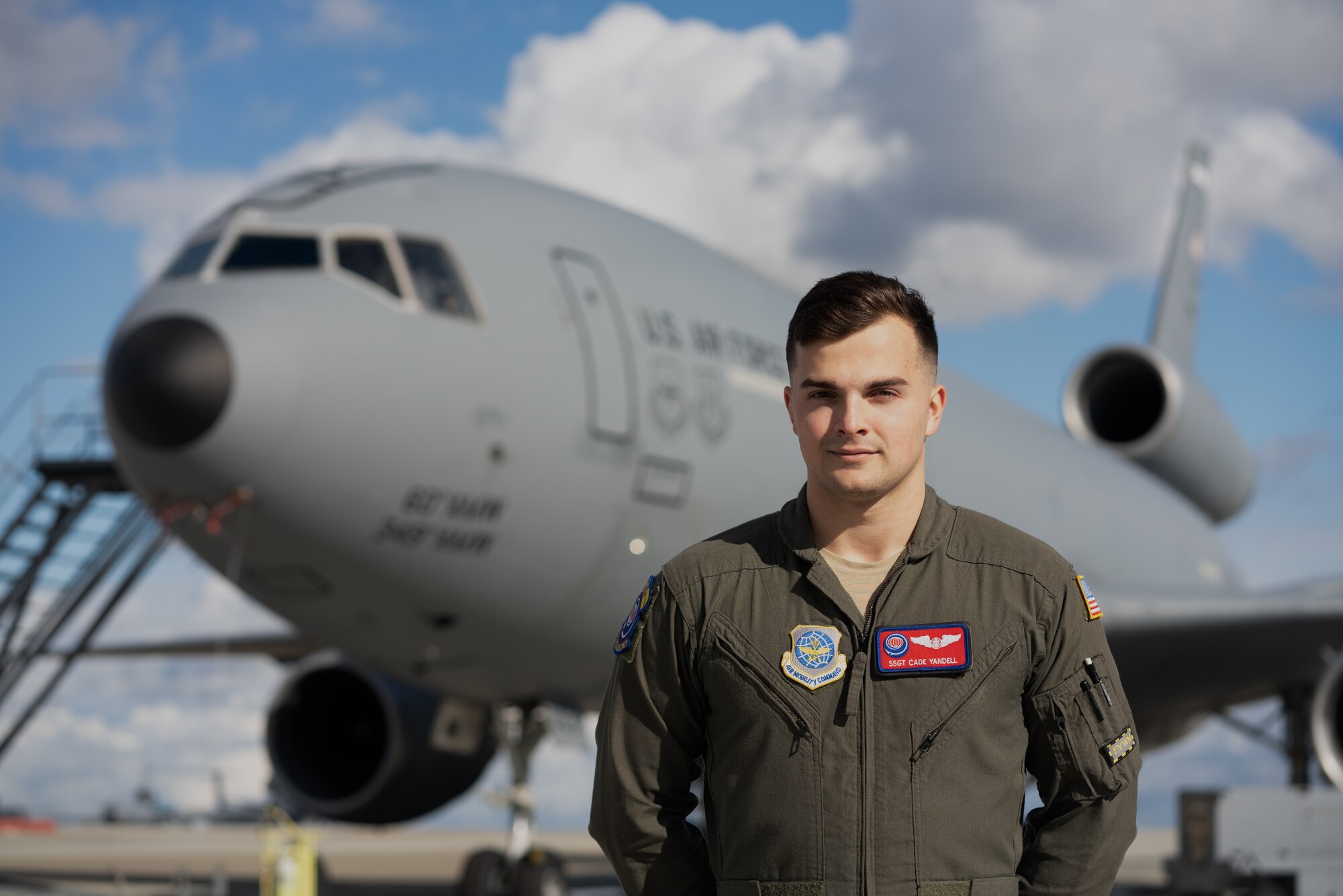 Airman poses in front of an aircraft
