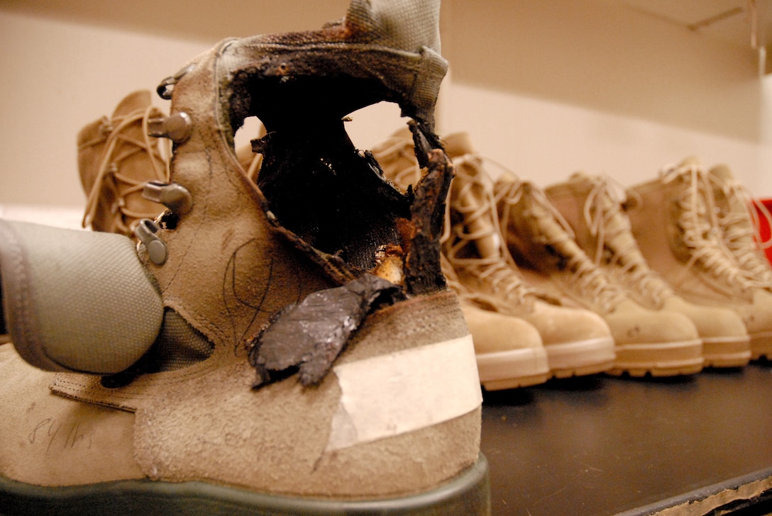 Brown combat boots with a black, charred section above the heel