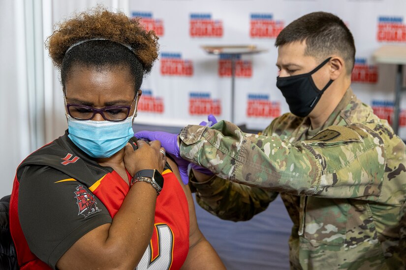 Indiana National Guard Staff Sgt. Colin Singleton, Indiana Medical Detachment combat medic specialist, administers a COVID-19 vaccine to Audrey Lee, U.S. Army Financial Management Command accountant, at the Johnson County Armory in Franklin, Indiana, Feb. 5, 2021. Lee was one of several USAFMCOM mission essential personnel who received their first round of vaccines along with more than 100 others that morning. (U.S. Army photo by Mark R. W. Orders-Woempner)