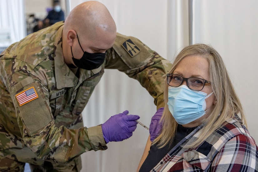 Indiana National Guard Spc. Ralph Myars, 2nd Battalion, 152nd Infantry Regiment combat medic specialist, administers a COVID-19 vaccine to Kathy Lauve, U.S. Army Financial Management Command executive assistant, at the Johnson County Armory in Franklin, Indiana, Feb. 5, 2021. Lauve was one of several USAFMCOM personnel who received their first round of vaccines along with more than 100 others that morning. (U.S. Army photo by Mark R. W. Orders-Woempner)