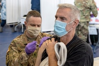 Indiana National Guard Sgt. 1st Class Kenneth E. Fodrie II, 38th Division Headquarters Battalion personnel staff noncommissioned officer with medic training, administers a COVID-19 vaccine to John Rosado, U.S. Army Financial Management Command military pay analyst, at the Johnson County Armory in Franklin, Indiana, Feb. 5, 2021. Rosado was one of several USAFMCOM mission essential personnel who received their first round of vaccines along with more than 100 others that morning. (U.S. Army photo by Mark R. W. Orders-Woempner)