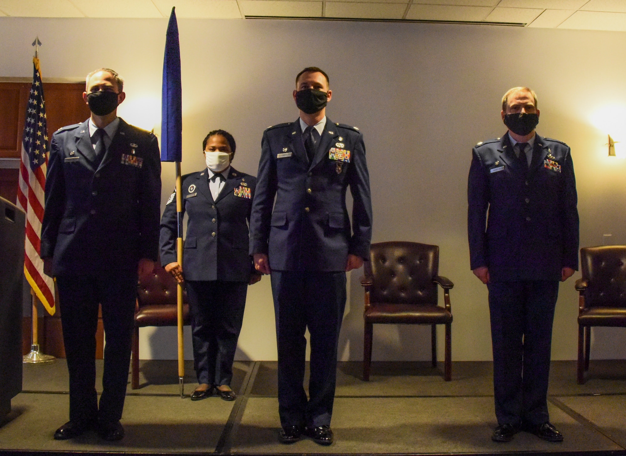 Four service members stand at attention.