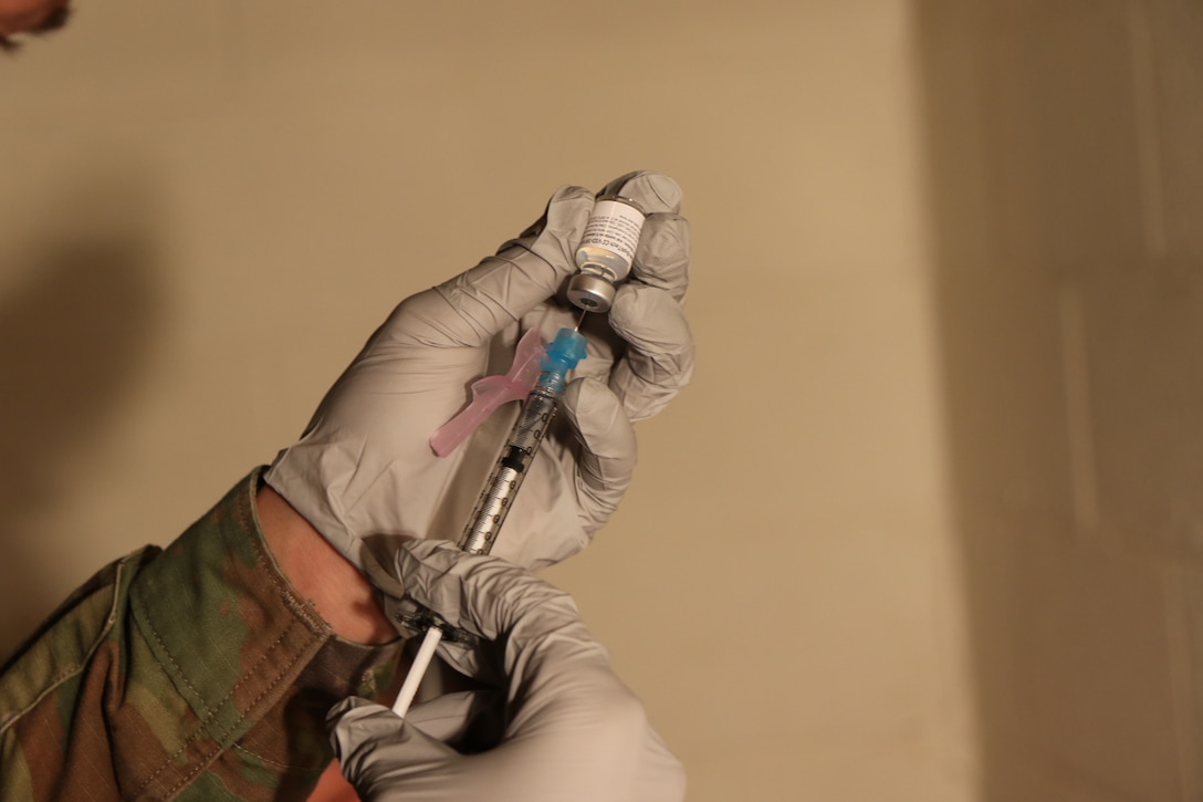 A soldier prepares a syringe.