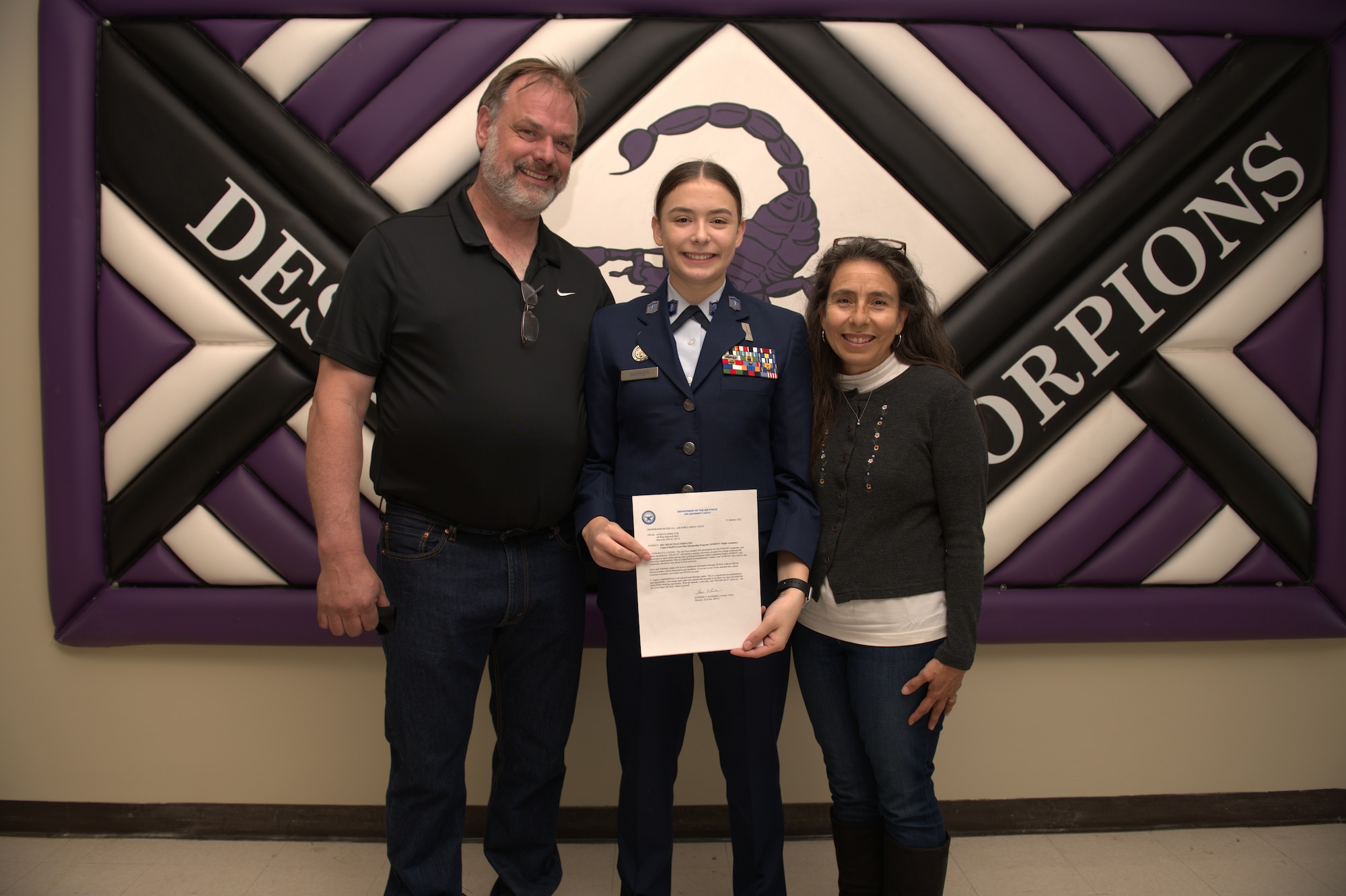 Air Force Junior ROTC Cadet Nicole Warner, a student at Desert Junior Senior High School on Edwards Air Force Base, Calif., poses with parents Aric Warner and Alma Warner during a brief ceremony in Desert JSHS, Feb. 10. Nicole, 17, was recently selected to receive a scholarship to attend an accredited aviation university participating in a private pilot license-training program in the summer of 2021.