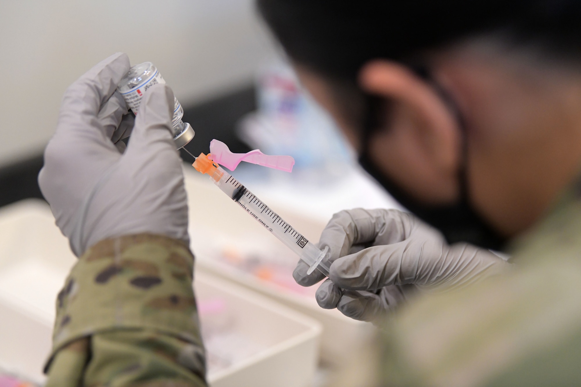 Tech. Sgt. Maryphille Sandoval, a pharmacy technician from the 18th Medical Support Squadron, fills a syringe with the Moderna COVID-19 vaccine, Jan. 29, 2021, at Kadena Air Base, Japan. As part of the DoD strategy for prioritizing, distributing and administering the COVID-19 vaccine, those providing direct medical care and emergency services will be prioritized to receive the vaccine at units based in Japan, including Kadena AB. (U.S. Air Force photo by Airman 1st Class Rebeckah Medeiros)