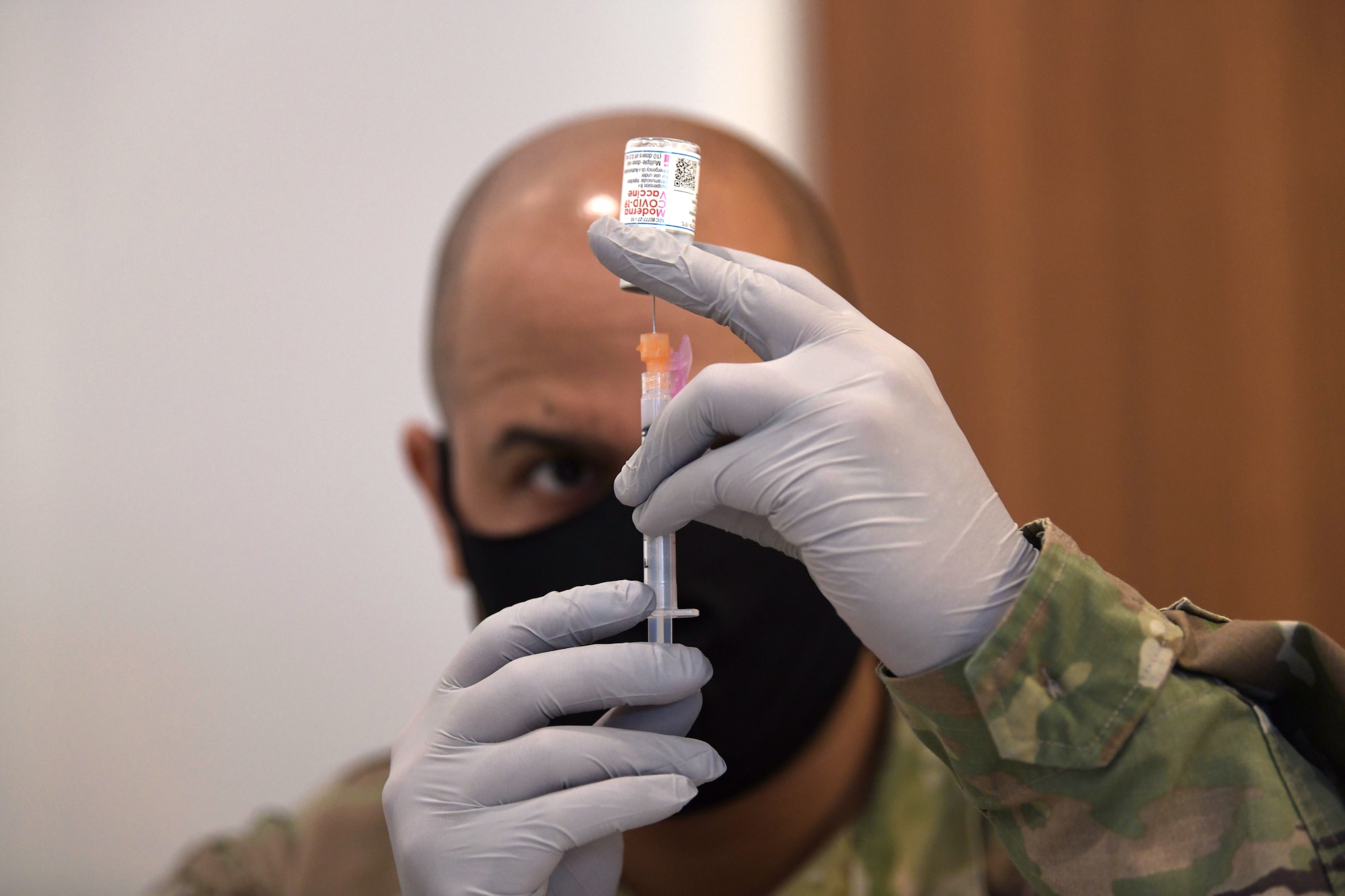 Tech. Sgt. Defabian Johnson, a pharmacy technician from the 18th Medical Support Squadron, fills a syringe with the Moderna COVID-19 vaccine in preparation for the receiving patient, Jan. 29, 2021, at Kadena Air Base, Japan. As part of the DoD strategy for prioritizing, distributing and administering the COVID-19 vaccine, those providing direct medical care and emergency services will be prioritized to receive the vaccine at units based in Japan, including Kadena AB. (U.S. Air Force photo by Airman 1st Class Rebeckah Medeiros)