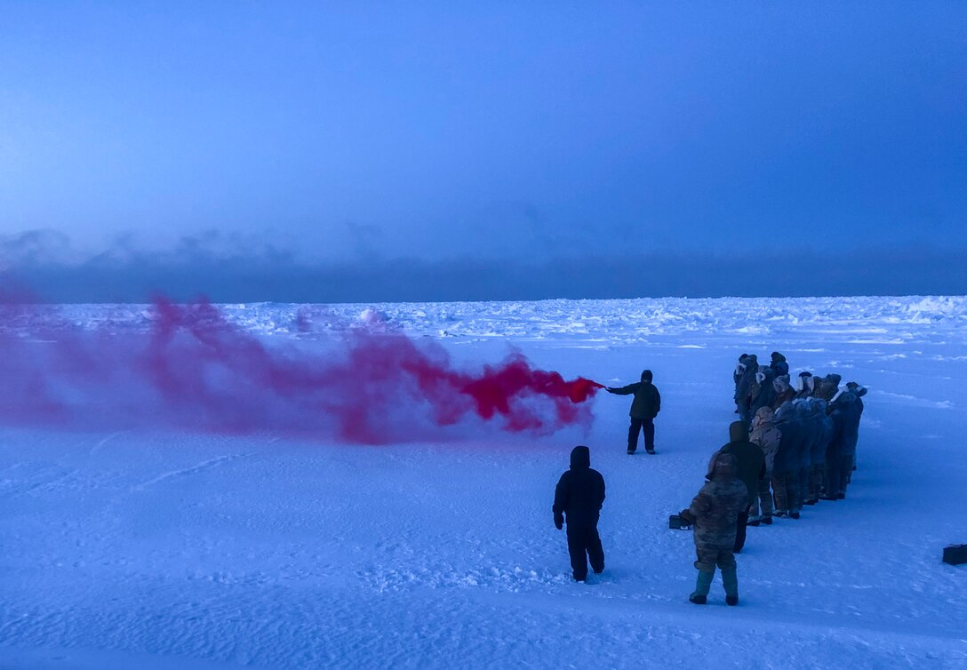 Staff Sgt. Samuel Ley, a 66th Training Squadron, Detachment 1 survival, evasion, resistance and escape, or SERE, specialist, demonstrates how to use an MK-124 smoke and illumination signal on the Chukchi Sea, Jan. 13, 2021. The MK-124 is a smoke and illumination flare used to signal search and rescue personnel in the event of an emergency or extraction situation.