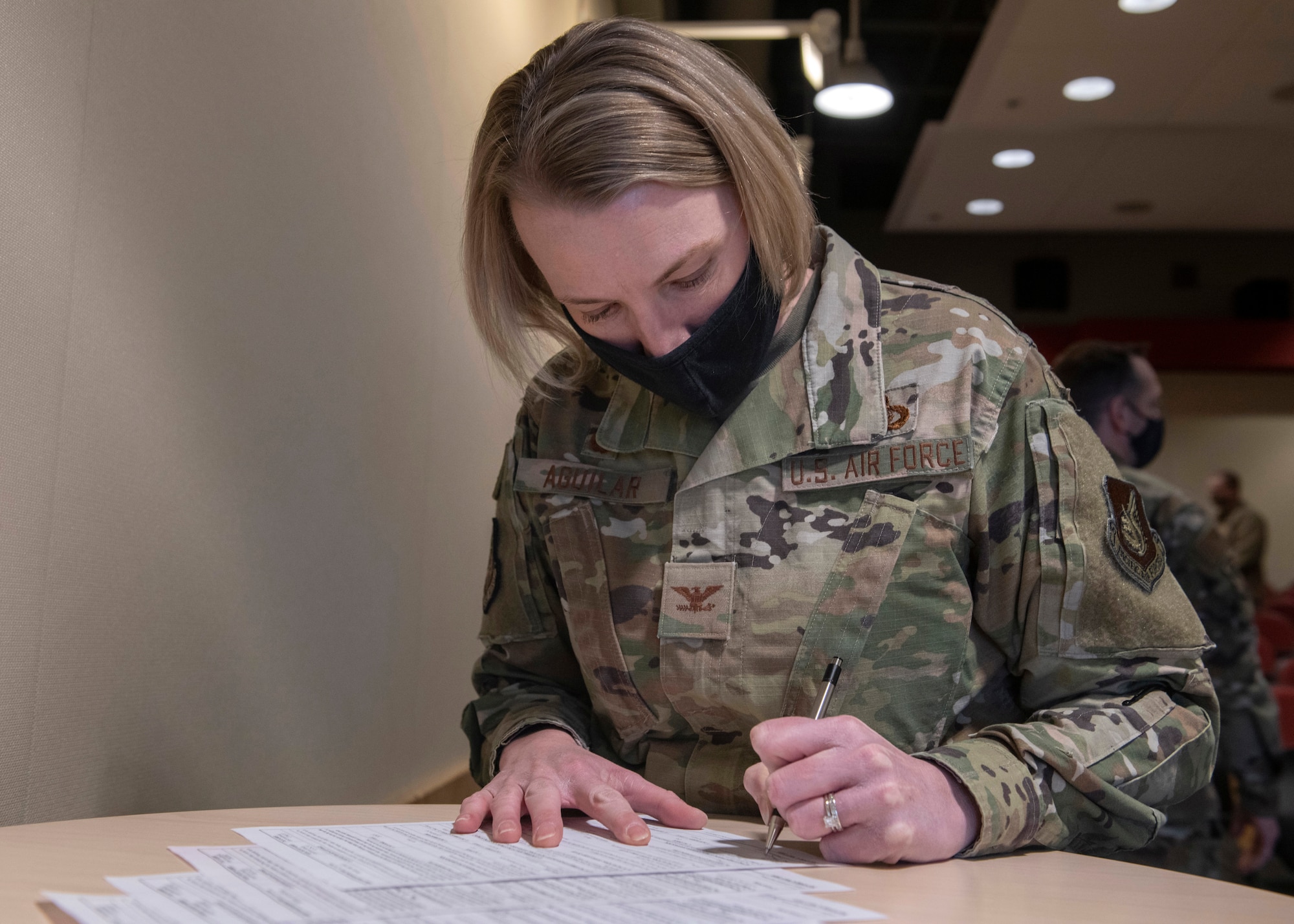 U.S. Air Force Col. Kirsten Aguilar, Joint Base Elmendorf-Richardson and 673d Air Base Wing commander, signs DD Form 4s during a U.S. Space Force transfer ceremony at Joint Base Elmendorf-Richardson, Alaska, Feb. 11, 2021. During the ceremony, JBER had seven Airmen earn their new title of Guardian by officially swearing into the newest branch of the armed forces.