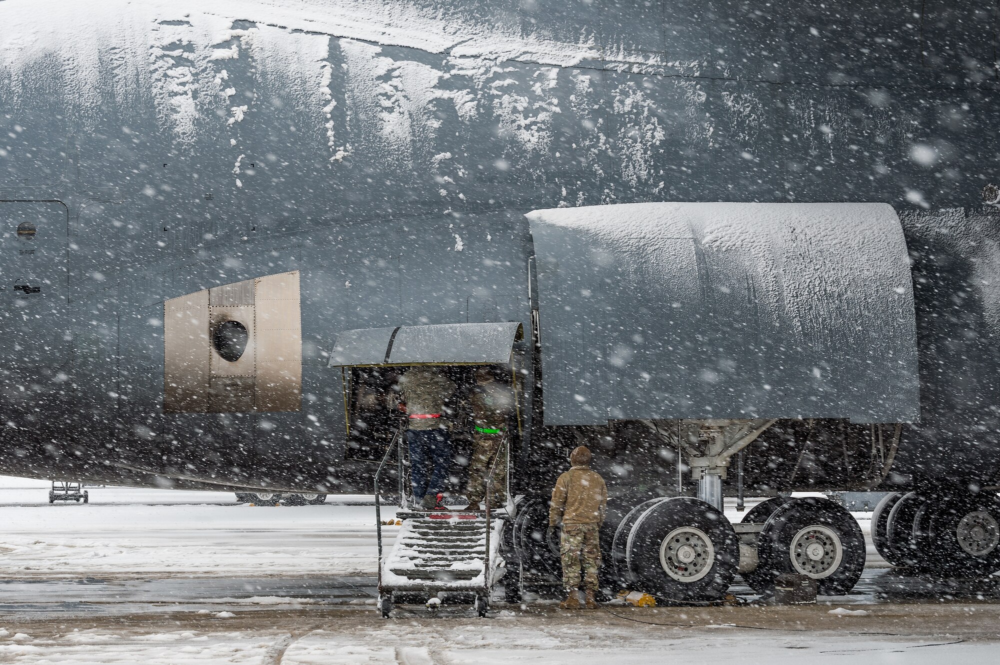 As snow fell, maintainers from the 436th Aircraft Maintenance Squadron performed maintenance on the right auxiliary power unit of a C-5M Super Galaxy at Dover Air Force Base, Delaware, Feb. 11, 2021. As Winter Storm Roland produced a wintry mix of precipitation, the base continued normal operations and prepared for additional forecast snowfall. (U.S. Air Force photo by Roland Balik)