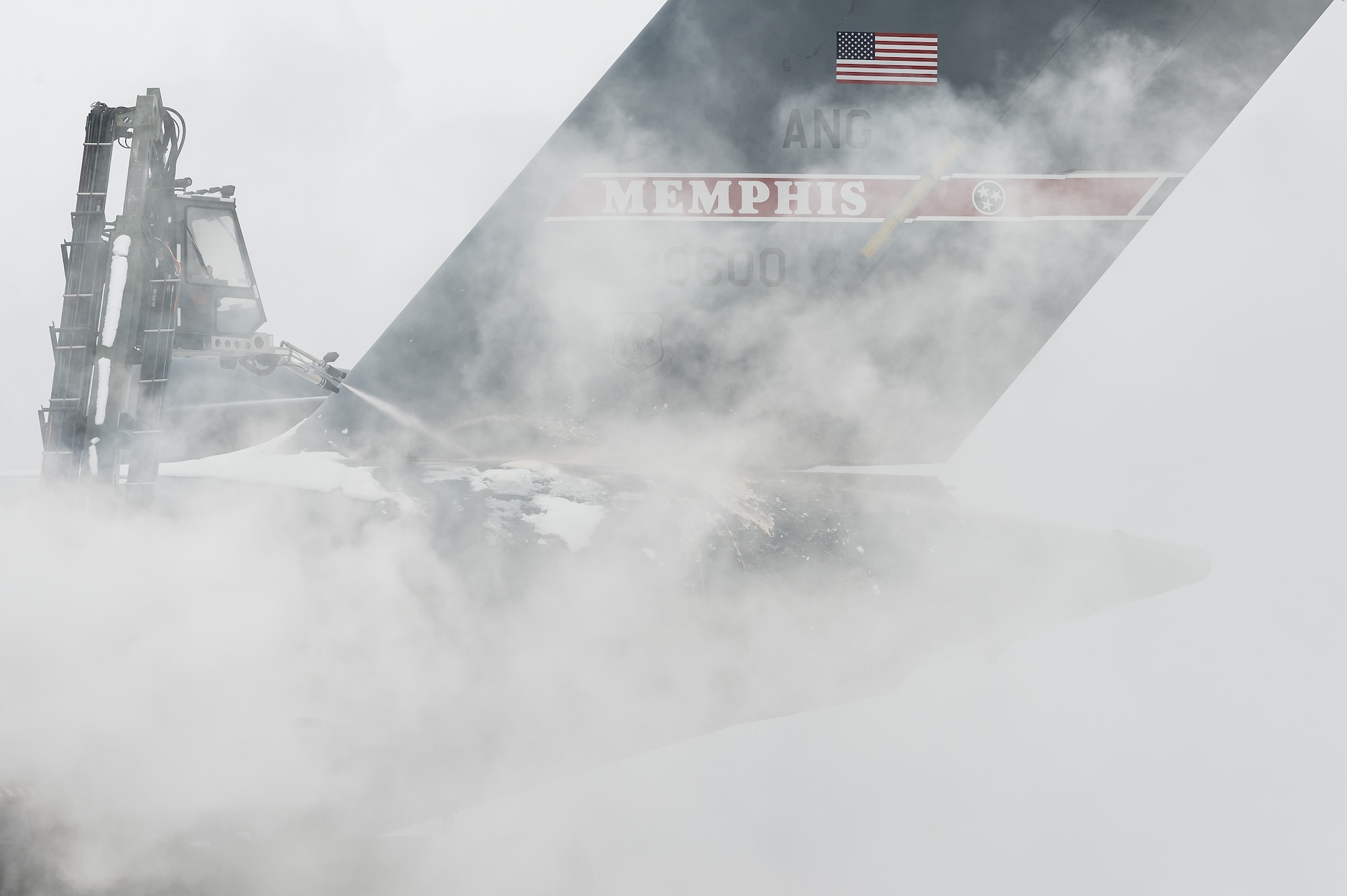 A de-icing vehicle removes snow from the aft fuselage of a transient Tennessee Air National Guard C-17 Globemaster III prior to departing Dover Air Force Base, Delaware, Feb. 11, 2021. As Winter Storm Roland produced a wintry mix of precipitation, the base continued normal operations and prepared for additional forecast snowfall. (U.S. Air Force photo by Roland Balik)