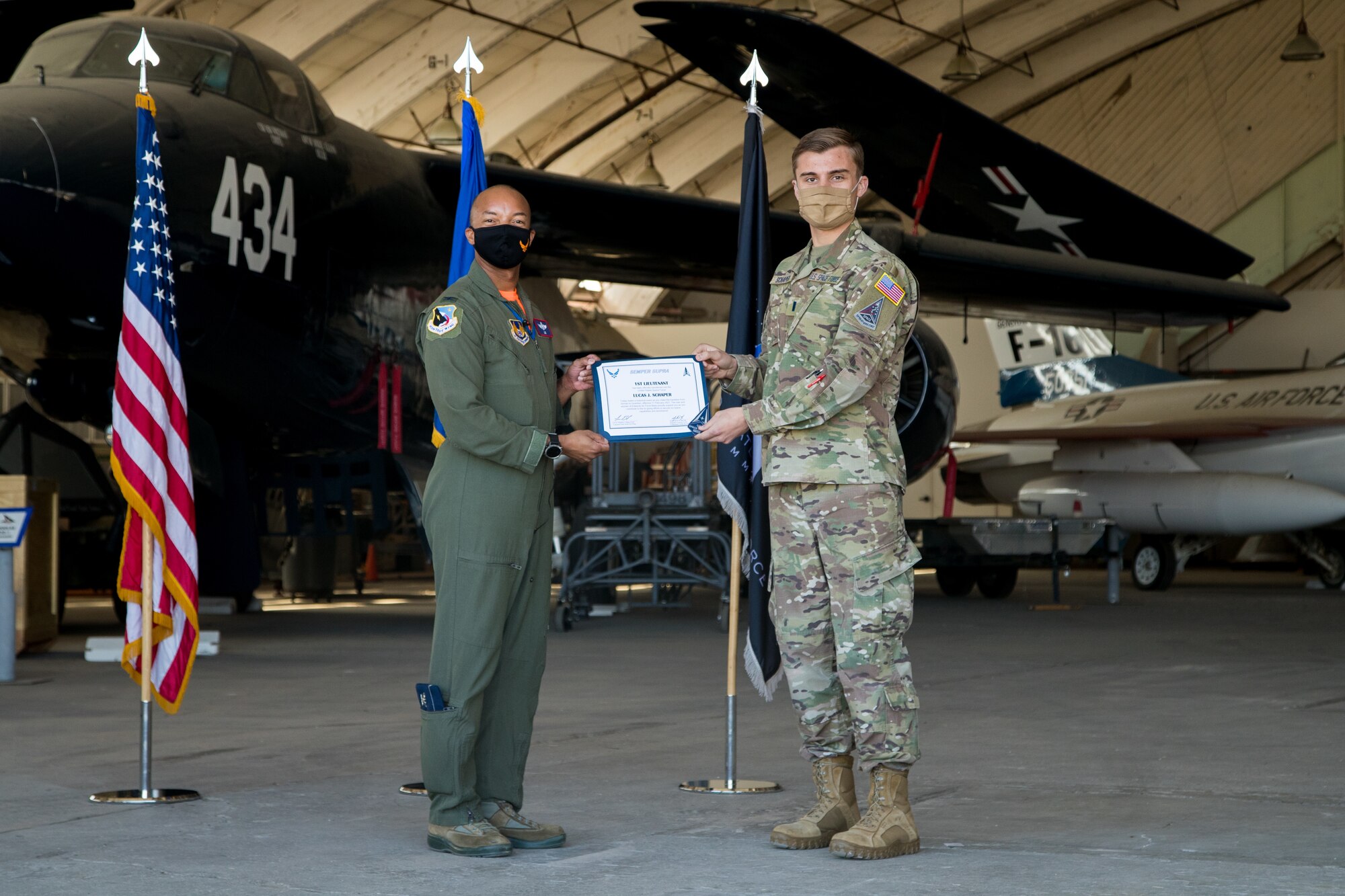 1st Lt. Lucas Schaper, Space Test Fundamentals Class 21-1, U.S. Air Force Test Pilot School, accepts his U.S. Space Force certificate from Col. Randel Gordon, 412th Test Wing Vice Commander, during a Space Force Transfer Ceremony at Edwards Air Force Base, California, Feb. 11. (Air Force photo by Richard Gonzales)