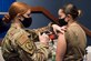 Airman 1st Class Dallas Telle (right), a client systems technician at the 709th Cyberspace Squadron at Patrick Space Force Base, Fla., rolls up her sleeve as Staff Sgt. Kameri Michaud (left), noncommissioned officer in charge of the 45th Medical Group's Pediatrics Clinic, administers the COVID-19 vaccine.  As a member of the Air Force Technical Applications Center's contingency response team, Telle received her first dose Jan. 14 and her second dose Feb. 11.  (U.S. Air Force photo by Matthew S. Jurgens)