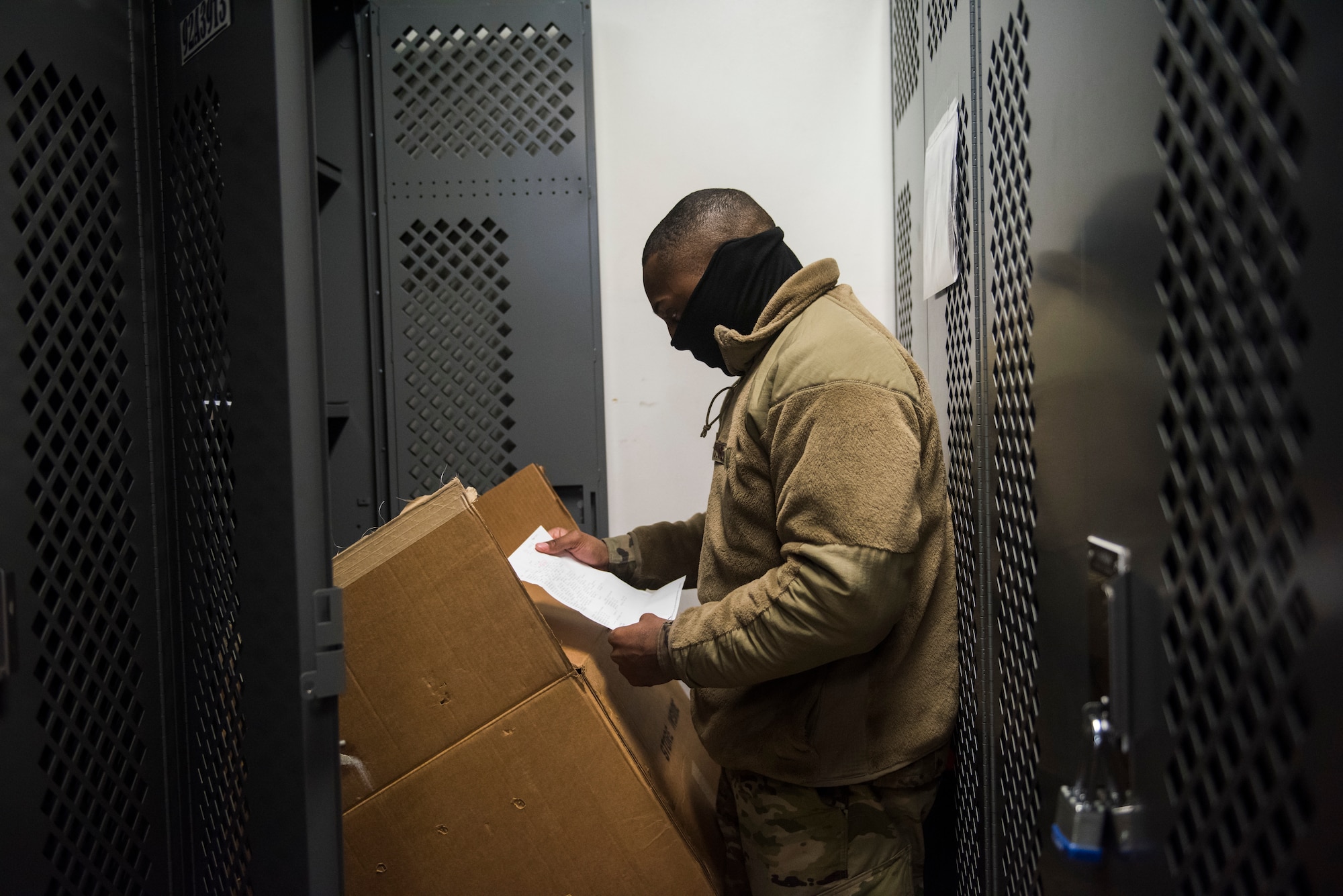 Man in uniform looking at supply equipment in storage facility