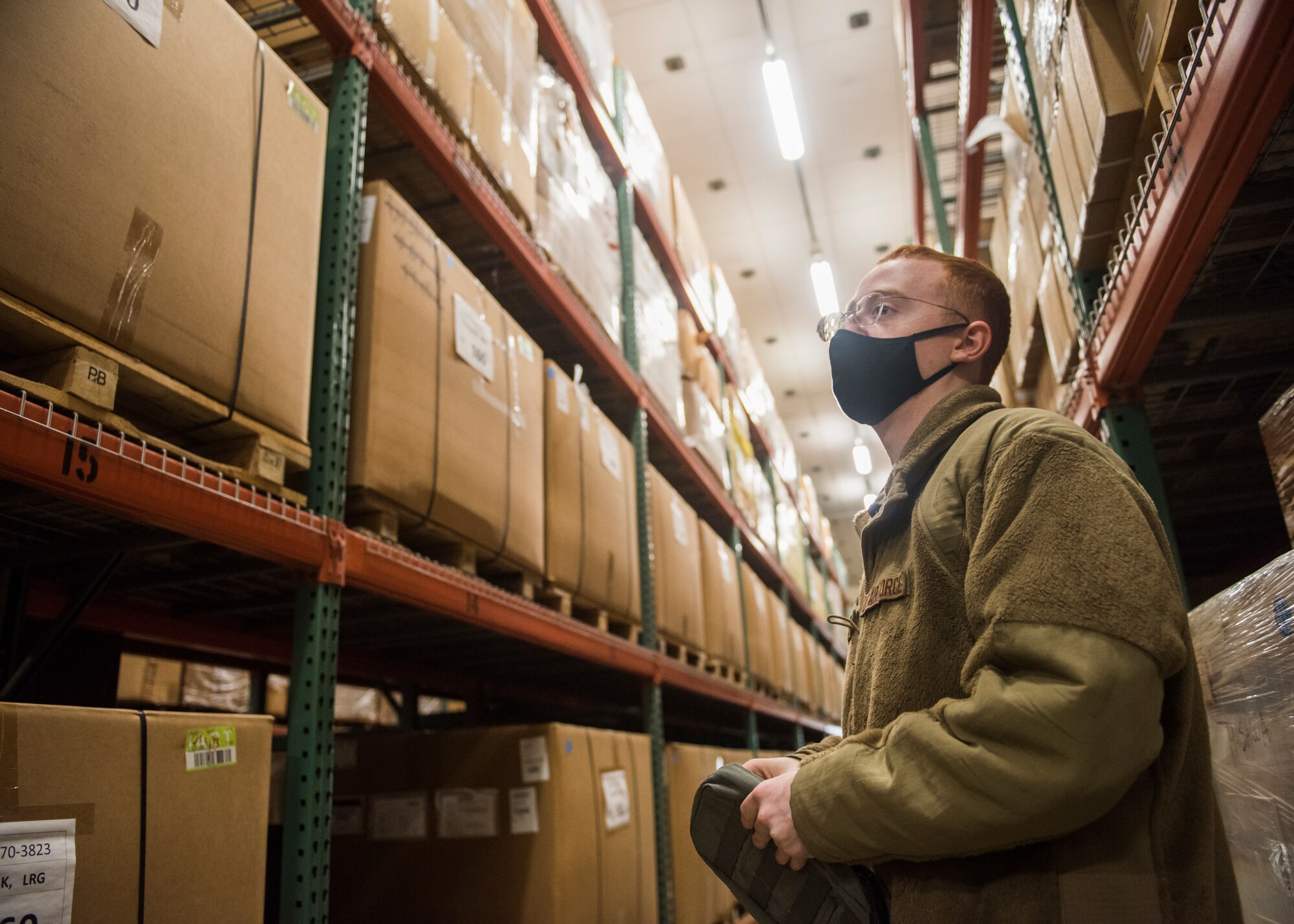 Man in uniform looking at boxes in a warehouse