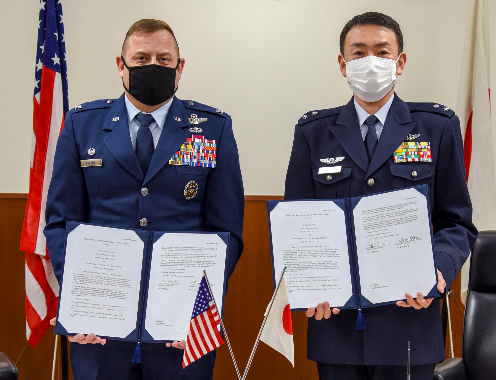 U.S. Air Force Col. Jesse J. Friedel, left, 35th Fighter Wing commander, and Japan Air Self-Defense Force Maj. Gen. Takahiro Kubota, 3rd Air Wing commander, pose for a photo with their signed copies of the Memorandum of Understanding International 3010 at Misawa Air Base, Japan, Feb. 12, 2021. The first of its kind to be signed in more than 20 years at Misawa, MOUI 3010 outlines the responsibilities associated with the joint or sole use, maintenance, repair, and construction of U.S. and Japanese owned facilities and areas on Misawa Air Base. (U.S. Air Force photo by Tech. Sgt. Timothy Moore)