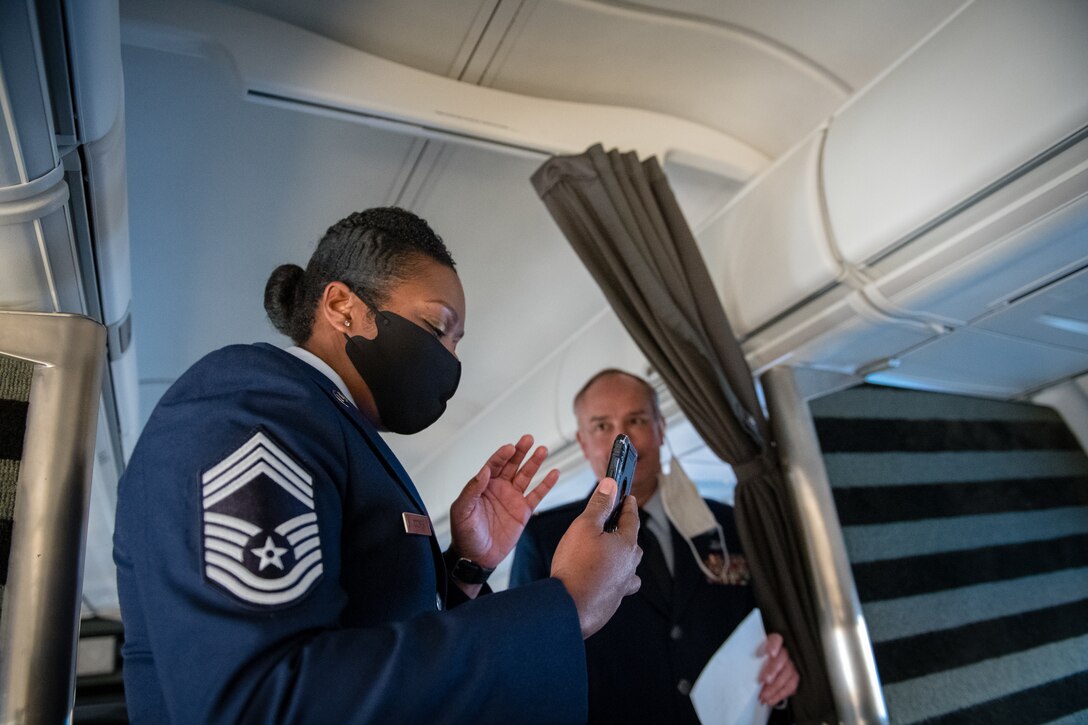 Chief Master Sgt. Monica Codner, 73rd Airlift Squadron superintendent, says hello to friends and family, viewing live on her phone,  just before the start of her promotion ceremony aboard a 932nd C-40C December 4, 2020, Scott Air Force Base, Illinois. (U.S. Air Force photo by Christopher Parr)