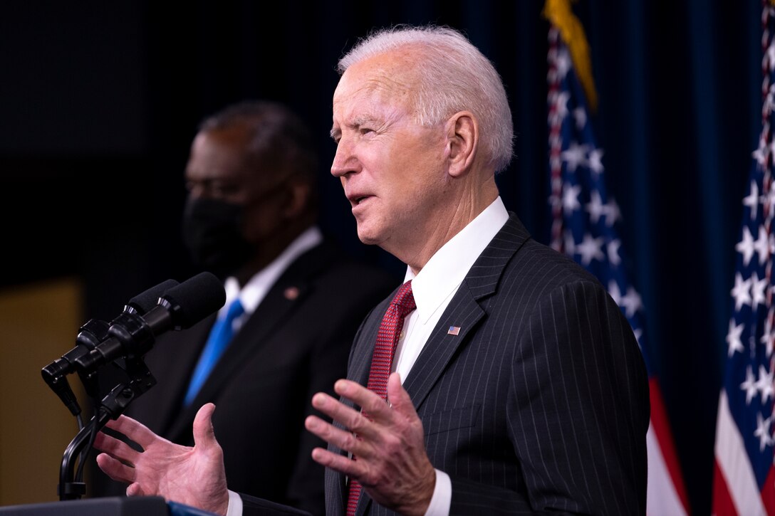 President Joe Biden speaks into a microphone.