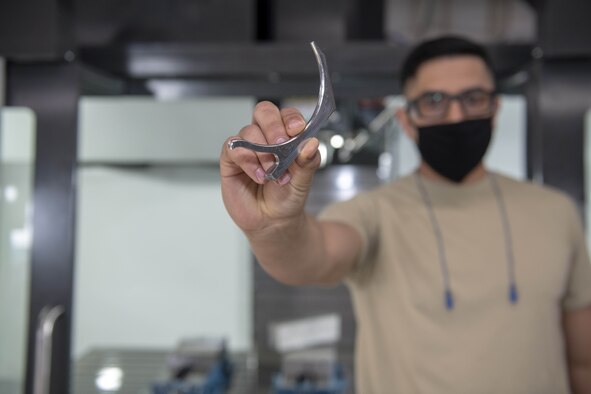 Photo of Airman holding aircraft part.