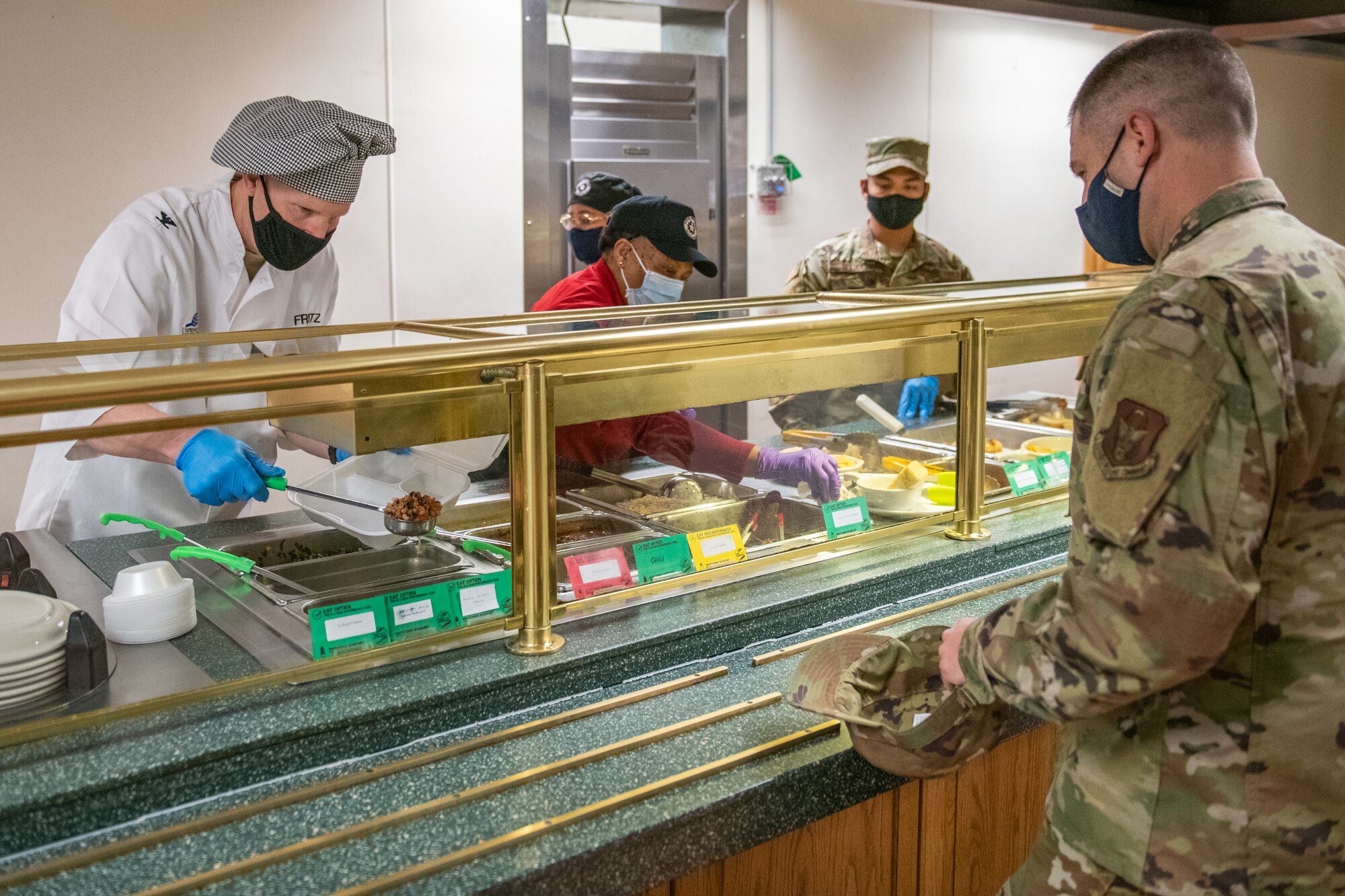 Col. Matthew Fritz, commander of the 419th Fighter Wing, serves lunch to Master Sgt. Aaron Jones, 419th Fighter Wing historian, while volunteering at the Hillcrest Dining Facility Feb. 6, 2021, at Hill Air Force Base, Utah.