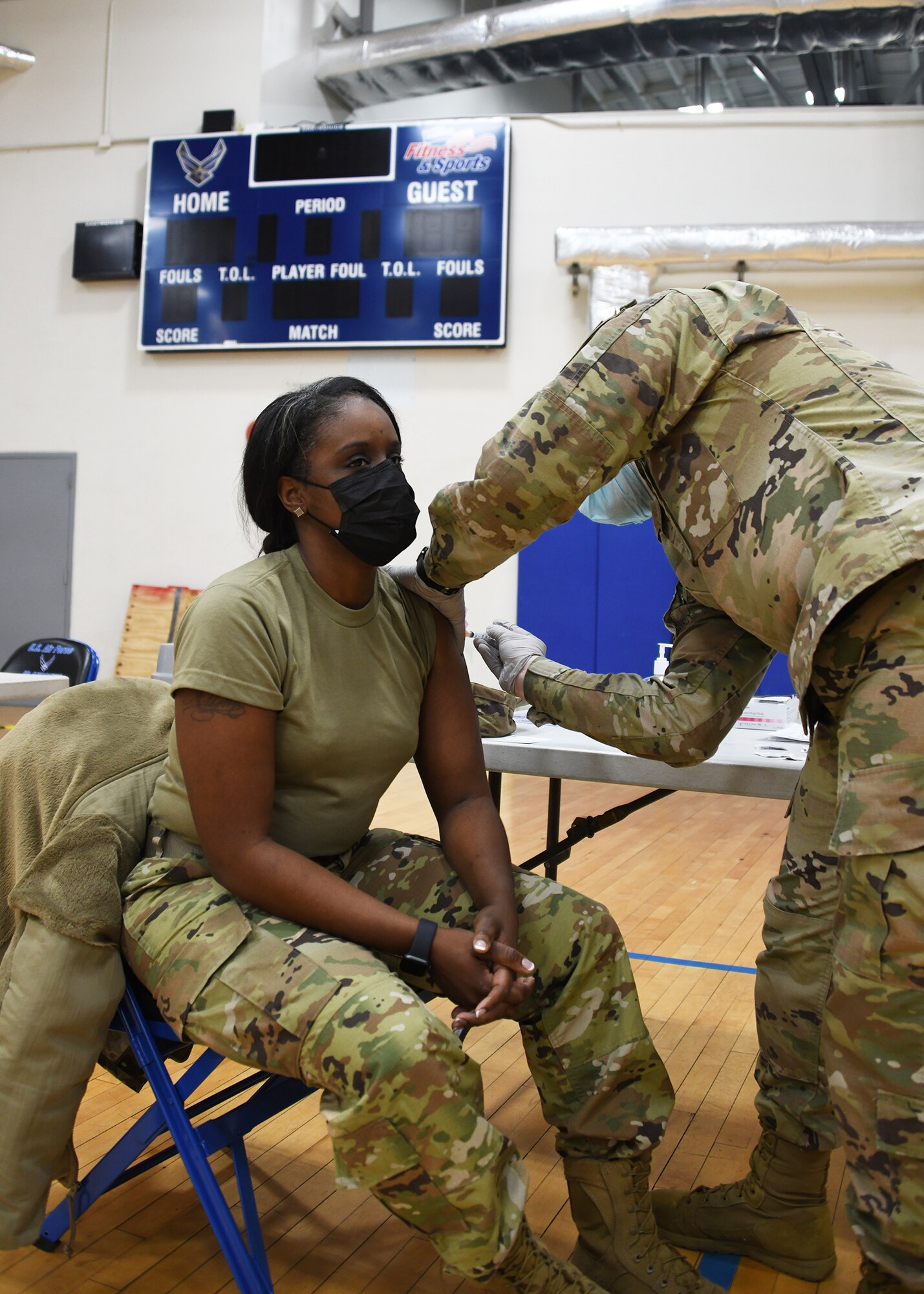 Master Sgt. Alisha Henderson, 459th Command Post, receives the COVID-19 vaccine from Staff Sgt. Kevin Nemo, 459th Aerospace Medicine Squadron medical technician Feb. 10th, 2021, at Joint Base Andrews, Md. The wing is now administering the vaccine to Airmen and DoD civilians. (U.S. Air Force photo by Staff Sgt. Cierra Presentado/Released)