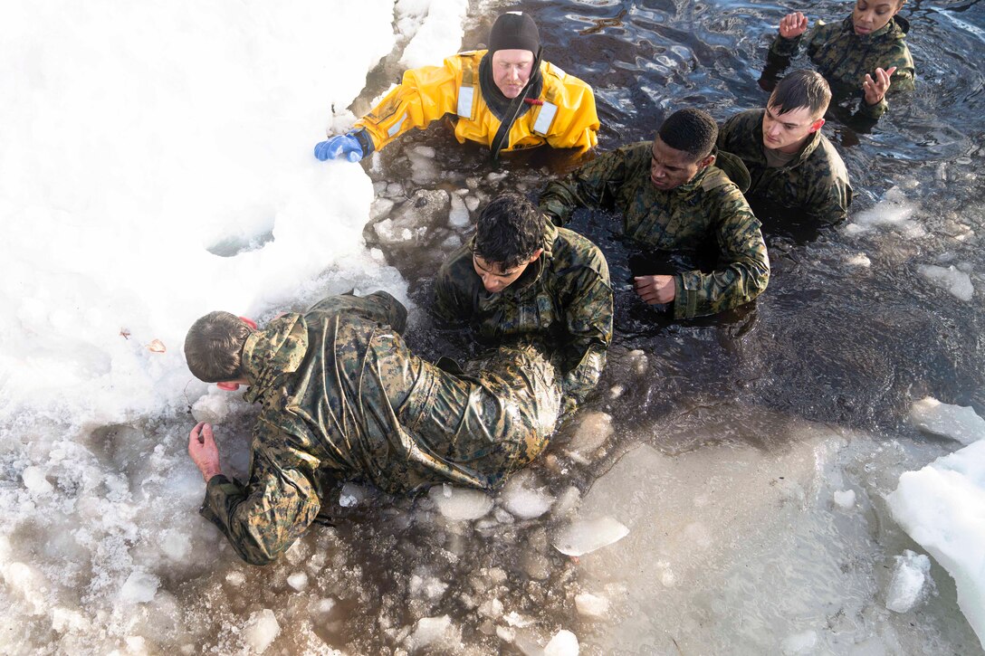 Marines exit a frozen pond.