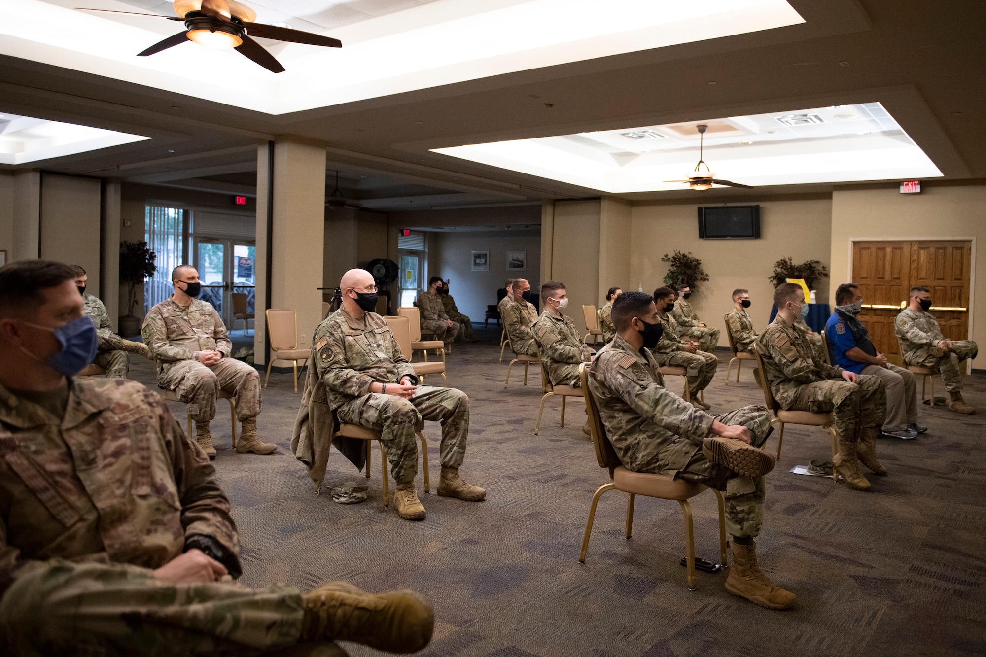 A photo of several Airmen sitting in chairs in the audience.
