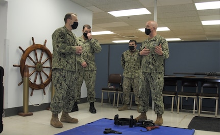 Rear Adm. Tom Anderson, Program Executive Officer, Ships, reviews the Firearms Training System (FATS), a new simulated use of force option that Sailors can use to fulfill their weapons qualifications training.