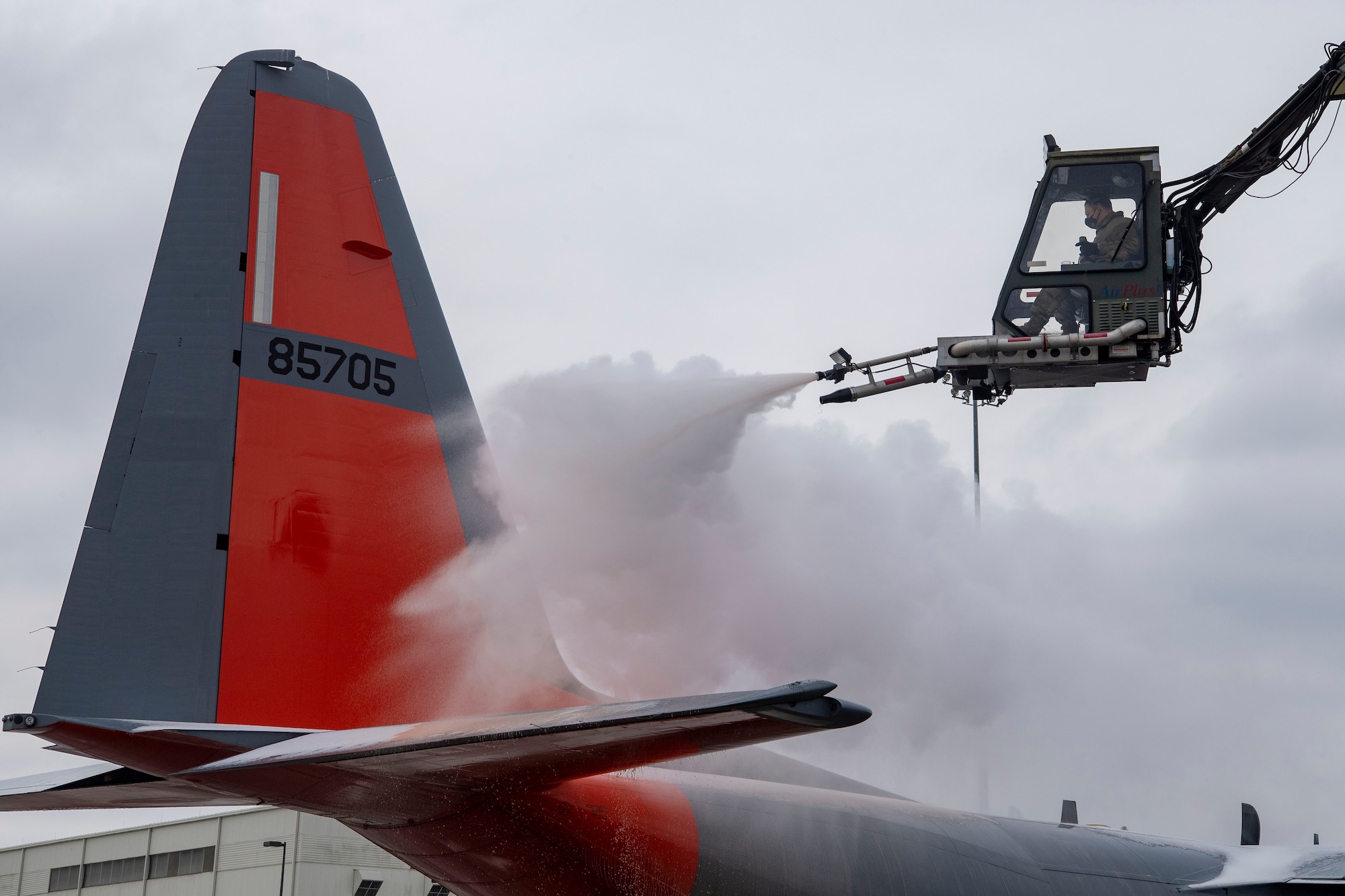 An Airman from the 19th AMXs de-ices the tail of a C-130J.