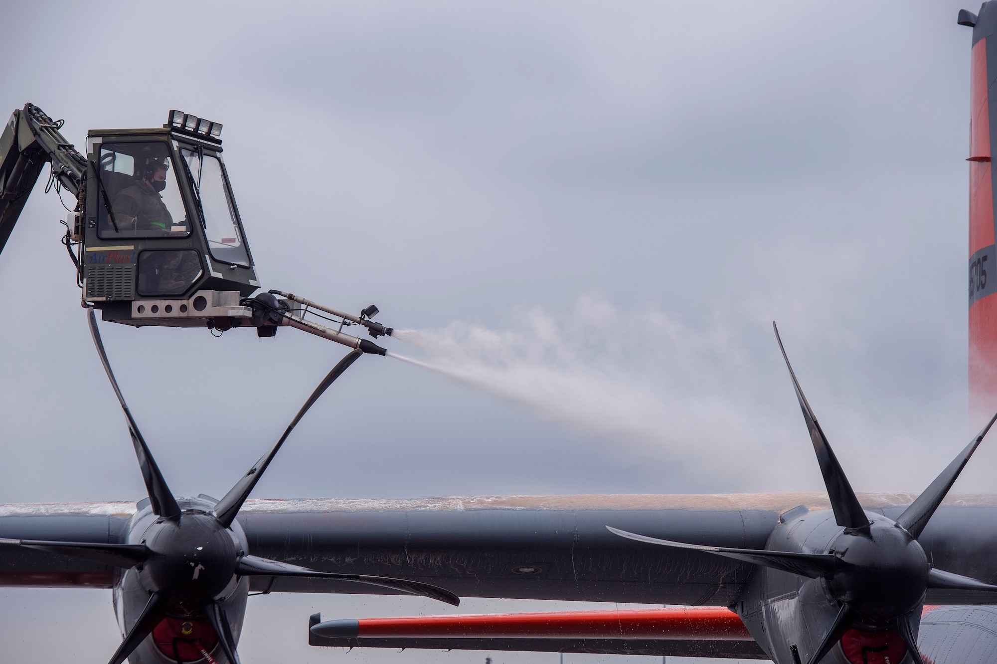 A crew chief de-ices the right wing of a C-130J Super Hercules.