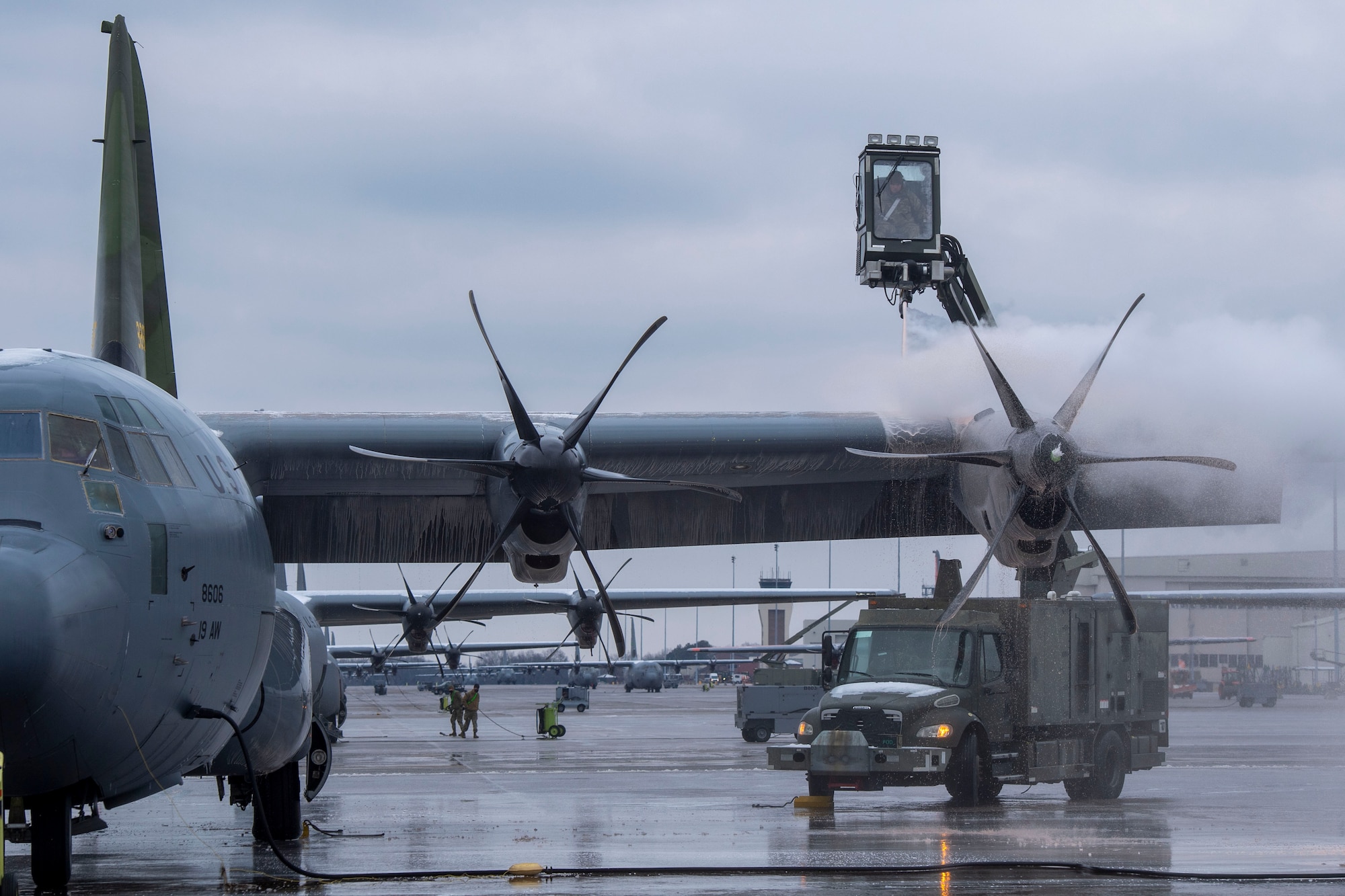 A crew chief de-ices a C-130J.