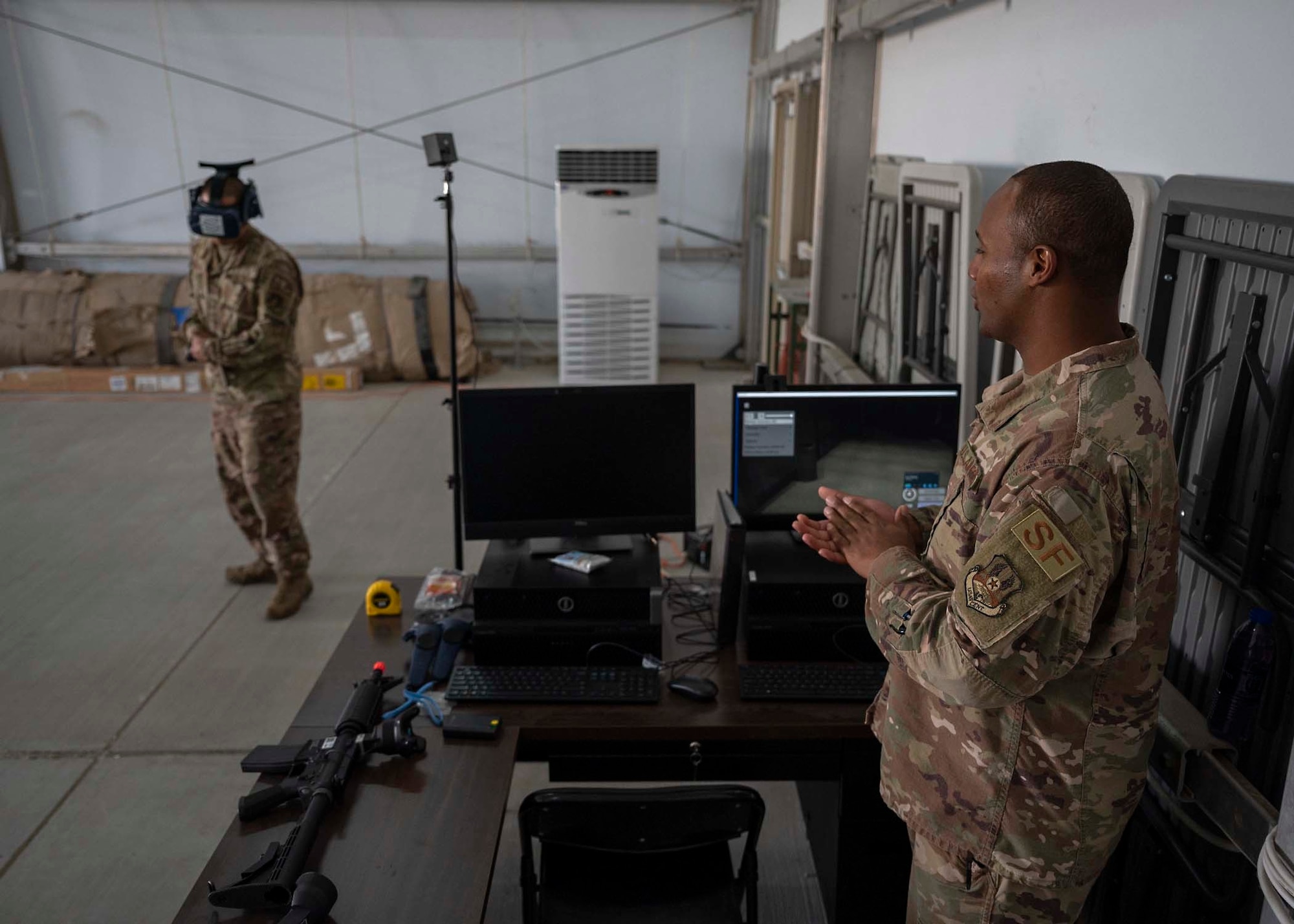 U.S. Air Force Tech. Sgt. Frank Unsioug (left), 380th Expeditionary Security Forces Squadron (ESFS) combat arms instructor, uses a virtual reality (VR) system in a virtual response as Master Sgt. Kenneth Greene (right), 380th ESFS training NCO in charge, analyzes his performance at Al Dhafra Air Base, United Arab Emirates, Jan. 20, 2020.