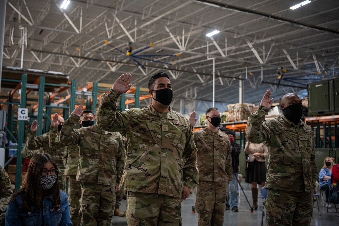 Men and Women take the oath of Enlistment at a ceremony.