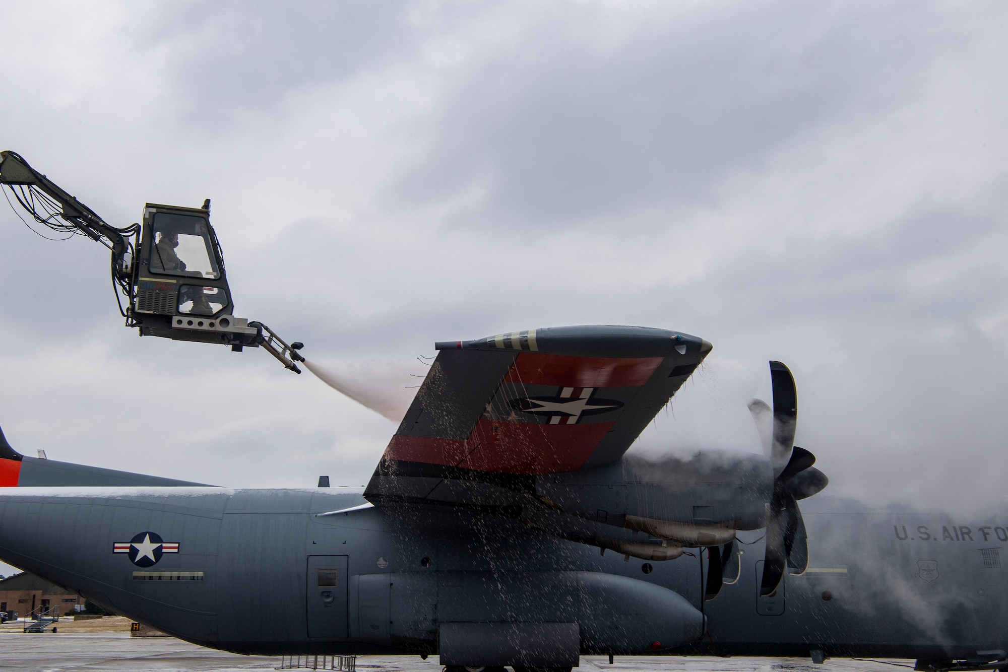 Maintenance Airmen de-ice the right wing of a C-130.