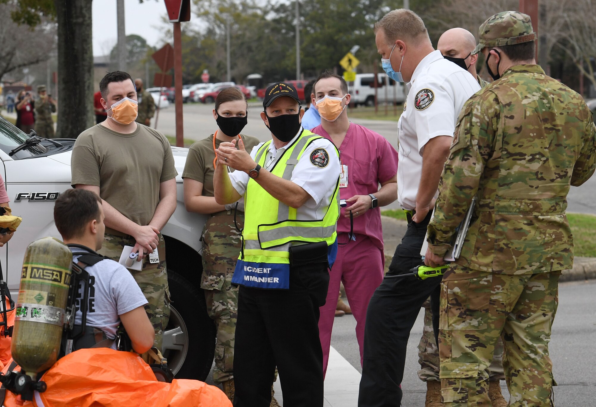 Chief James Donnett, 81st Civil Engineering Squadron fire chief, discusses the action plan with emergency response team members outside the Keesler Medical Center at Keesler Air Force Base, Mississippi, Feb. 11, 2021. Members of the Keesler Fire Department, 81st Security Forces Squadron, 81st Medical Group and Emergency Management responded to a suspicious package found inside the Keesler Medical Center. (U.S. Air Force photo by Kemberly Groue)