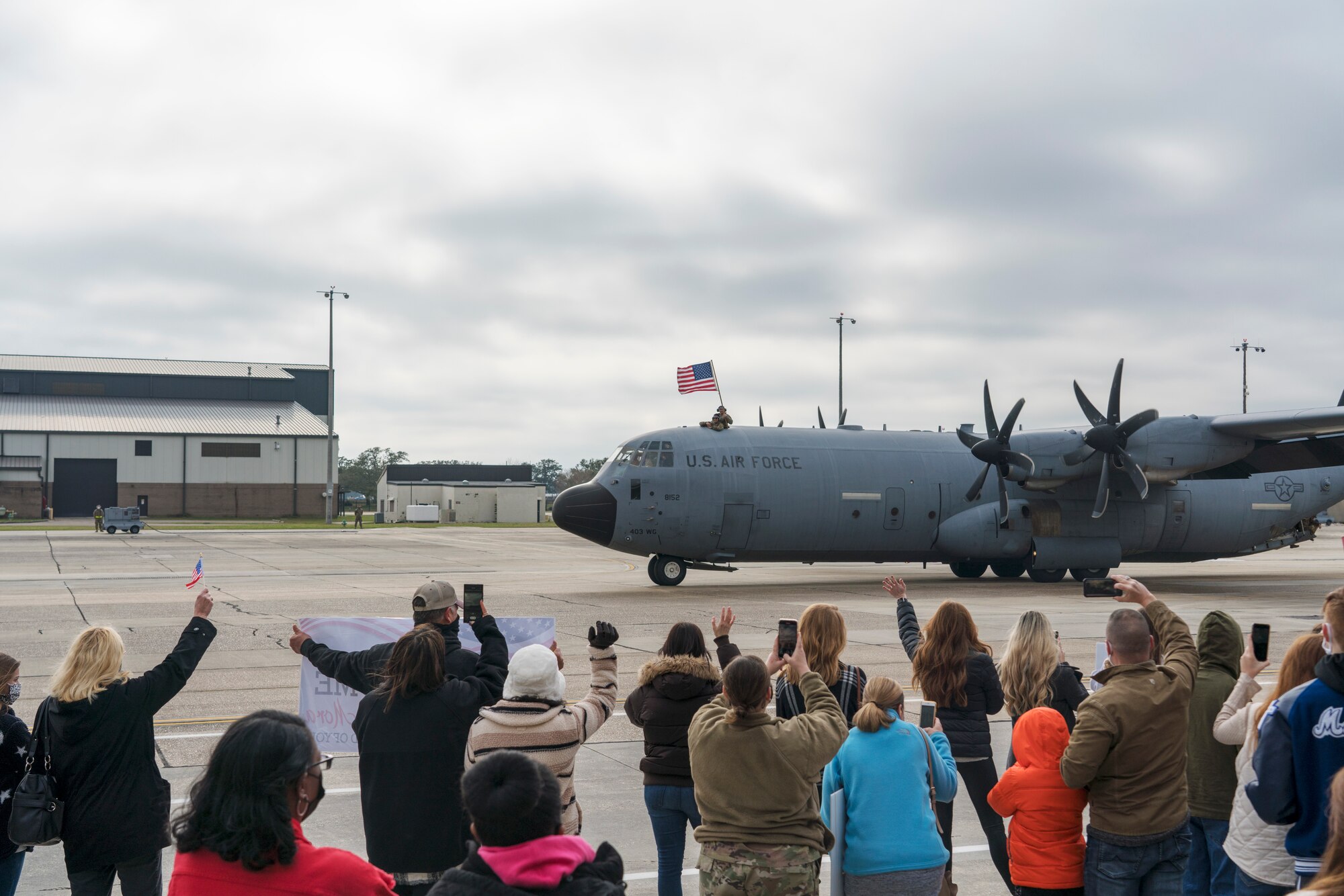 Family members await the return of their Reserve Citizen Airmen to Keesler Air Force Base, Mississippi, Feb. 13, 2021. Airmen from the 815th Airlift Squadron and maintenance and personnel from throughout the 403rd Wing were deployed to Southwest Asia where they supported Operations Freedom Sentinel and Inherent Resolve. (U.S. Air Force photo by 2nd Lt. Christopher Carranza)
