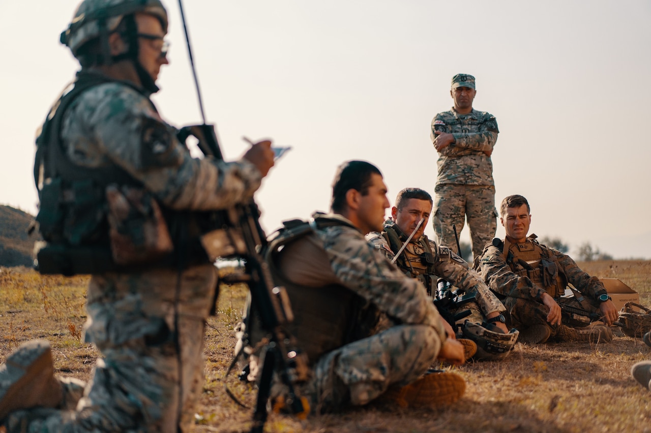 Foreign soldiers discuss a mission.