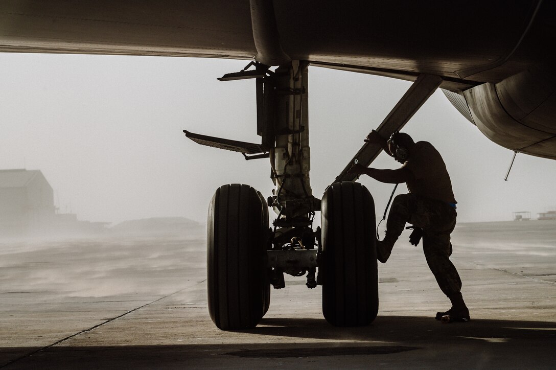 Man checks airplane landing gear