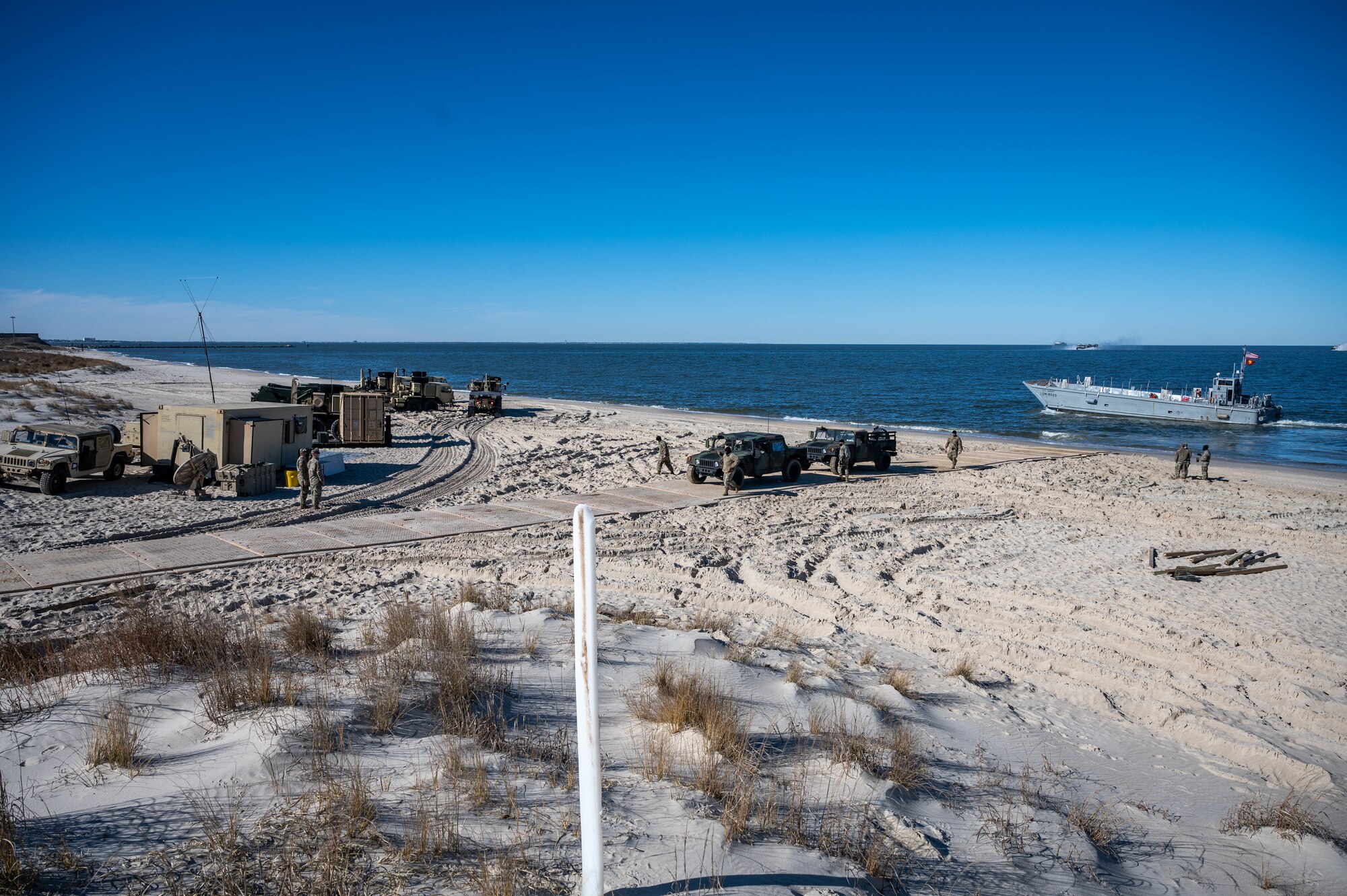 Humvees arrive at a beach.