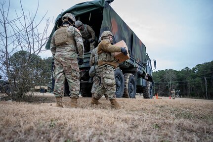 Soldiers unload a truck.