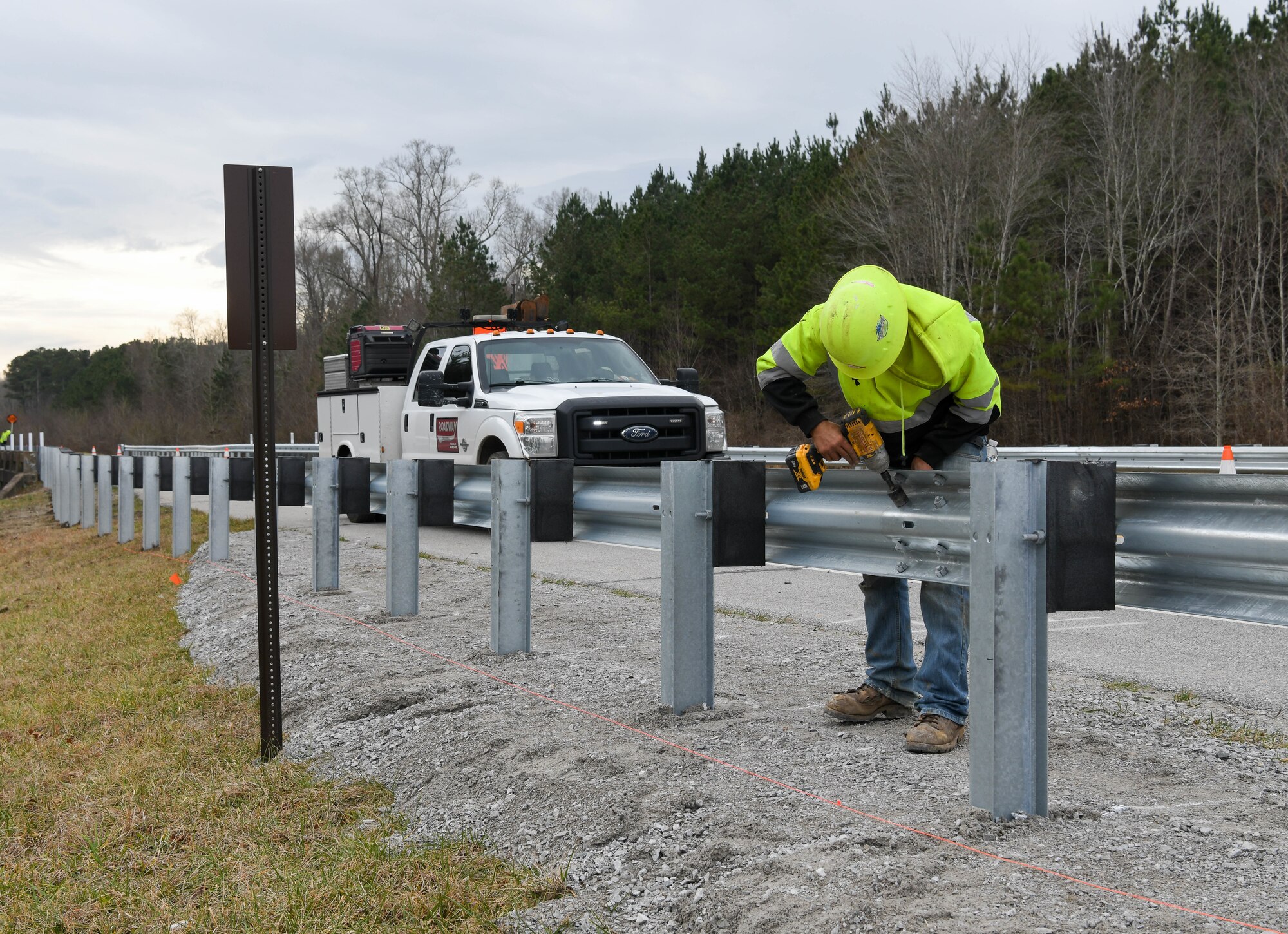 Ben Dees secures a section of guardrail while working on a crew installing new guardrails along Wattendorf Memorial Highway at Arnold Air Force Base, Tenn., Jan. 27, 2021. Guardrails were added to areas where the shoulder drops off and at bridge ends to increase safety for motorists. (U.S. Air Force photo by Jill Pickett)