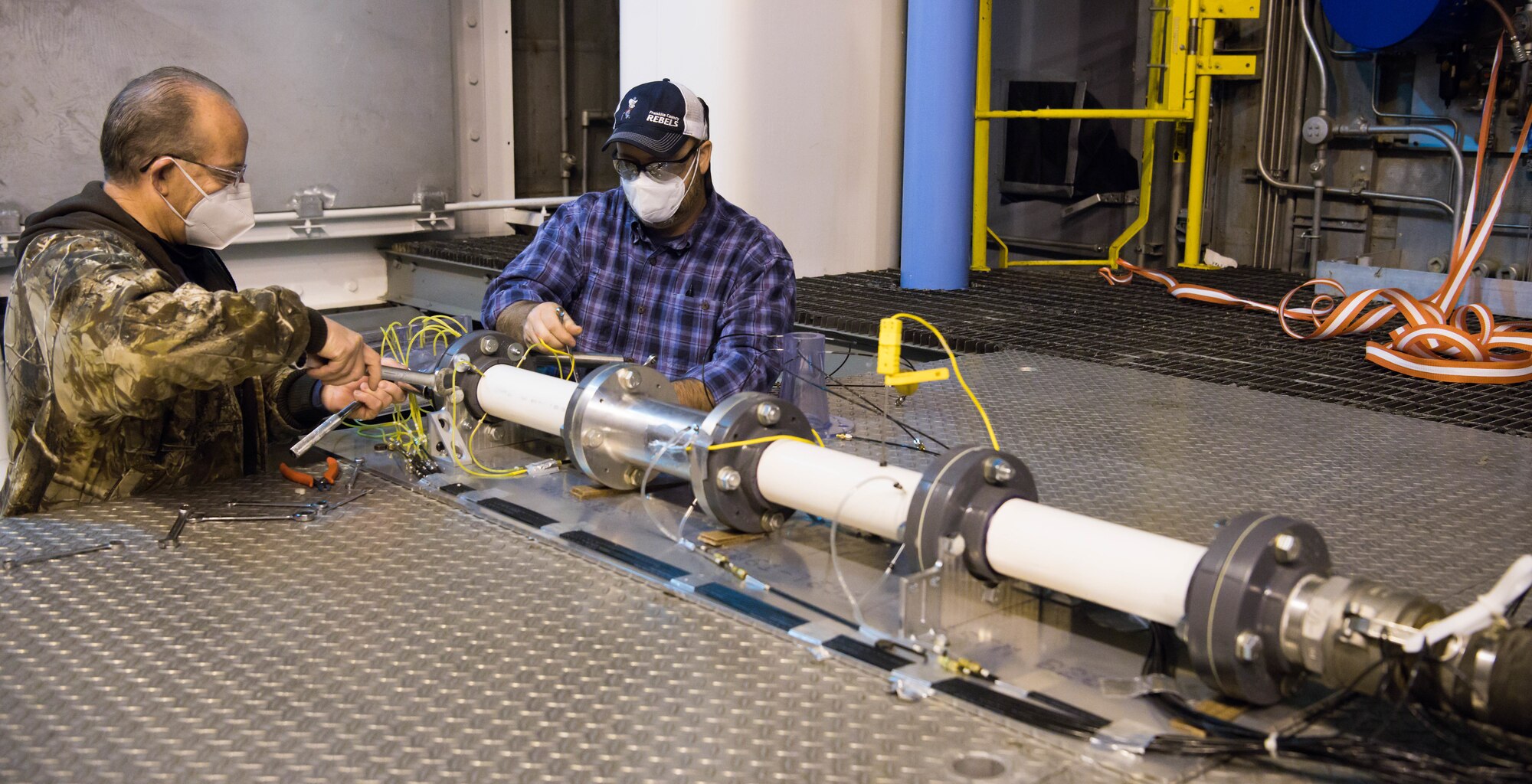 Jeff Tucker, left, machinist, and Alan Womack, machinist lead, change out test articles in the Sea Level 2 Test Cell, Dec. 17, 2020, at Arnold Air Force Base, Tenn. An Arnold Engineering Development Complex test team was researching the acoustic properties of two different nozzles. (U.S. Air Force photo by Jill Pickett)