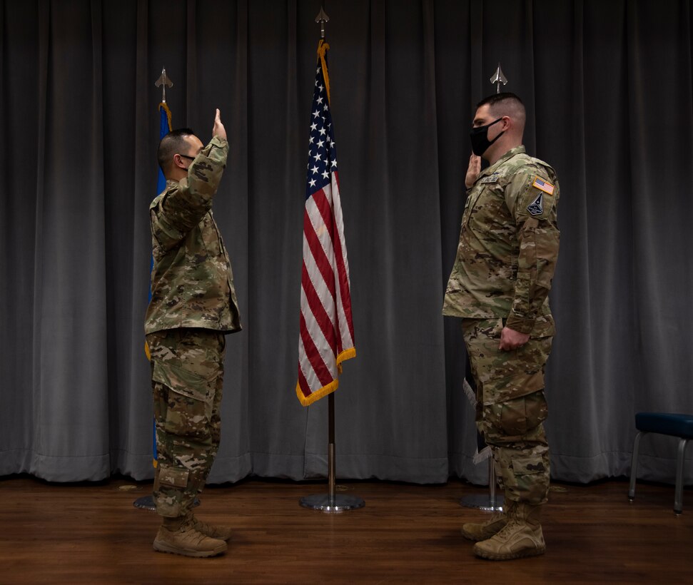 A standing Airman officer swears in a former standing Airman officer to the U.S. Space Force.