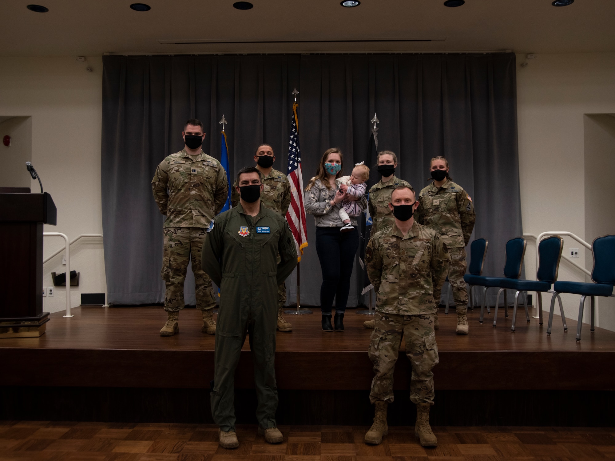 Four Guardians, a Airman, a Airman officer and a military spouse pose for a group photo.